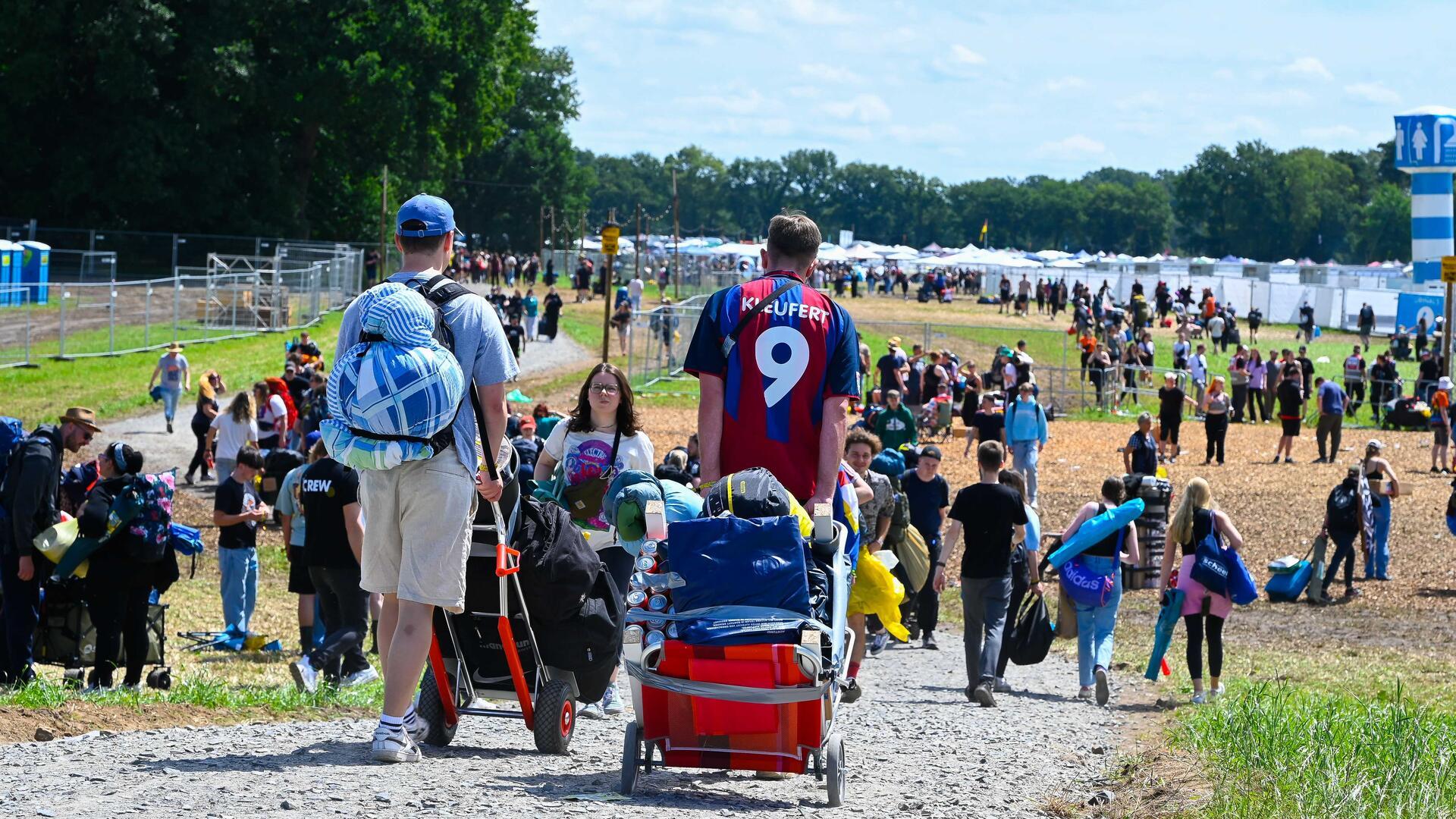 Mit Bollerwagen und Rucksack gehen vor allem junge Leute auf das Festivalgelände. Das Hurricane steht bevor. 