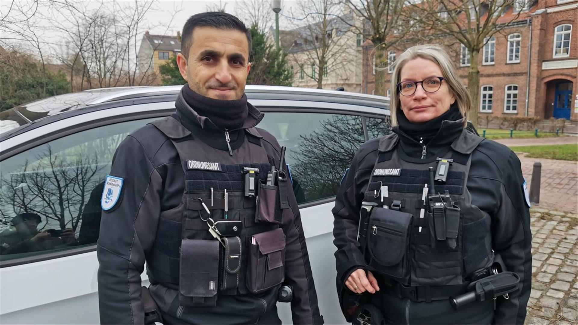 Ahmad Fandi und Claudia Renken vom Ordnungsamt Bremerhaven vor ihrem Fahrzeug