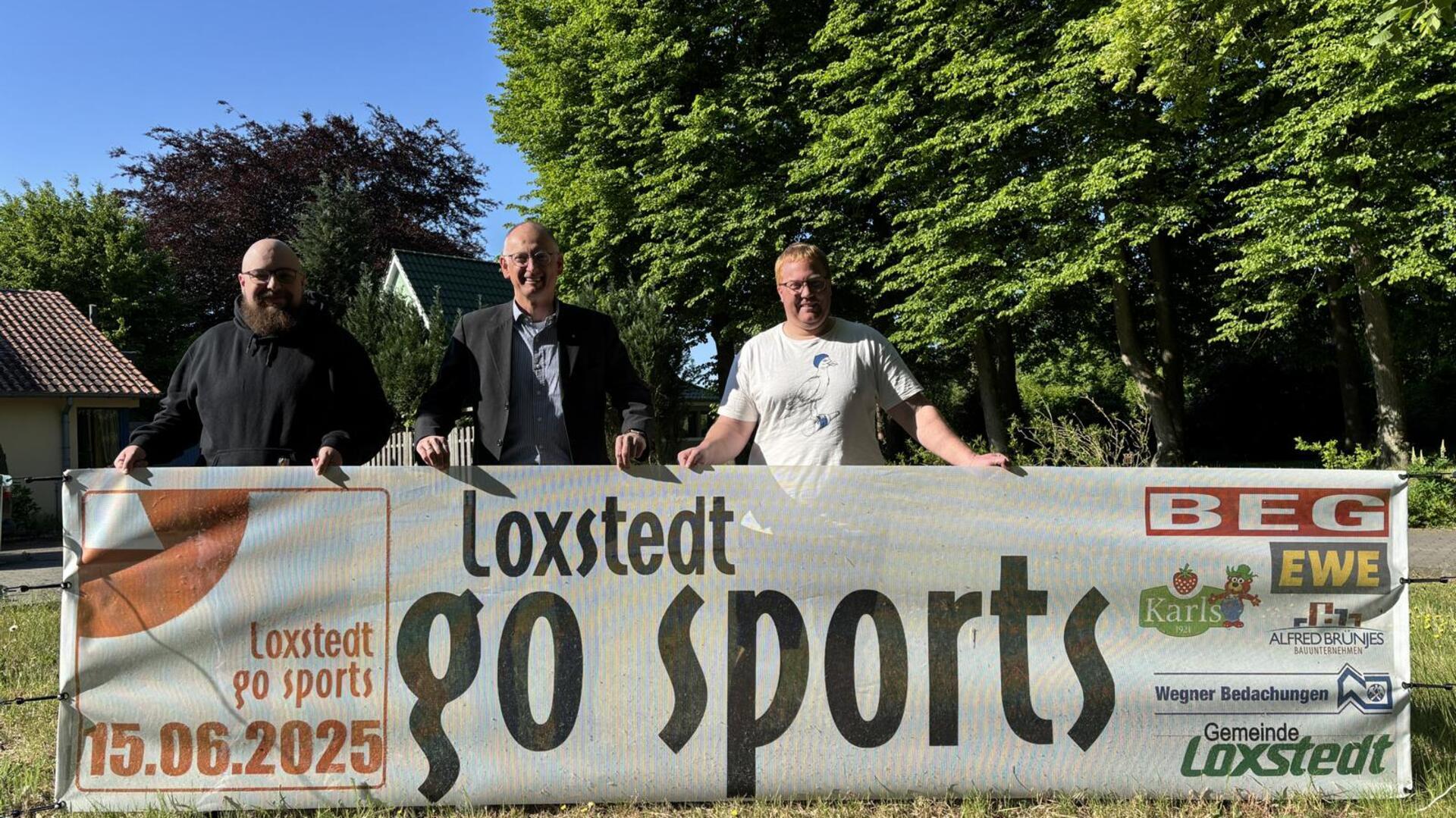 Jugendpfleger und Organisator Michael Ritter, Bürgermeister Detlef Wellbrock und Jugendpfleger und Organisator Jannik Böckhaus-Müller stehen hinter einem "Loxstedt go sports"-Plakat.