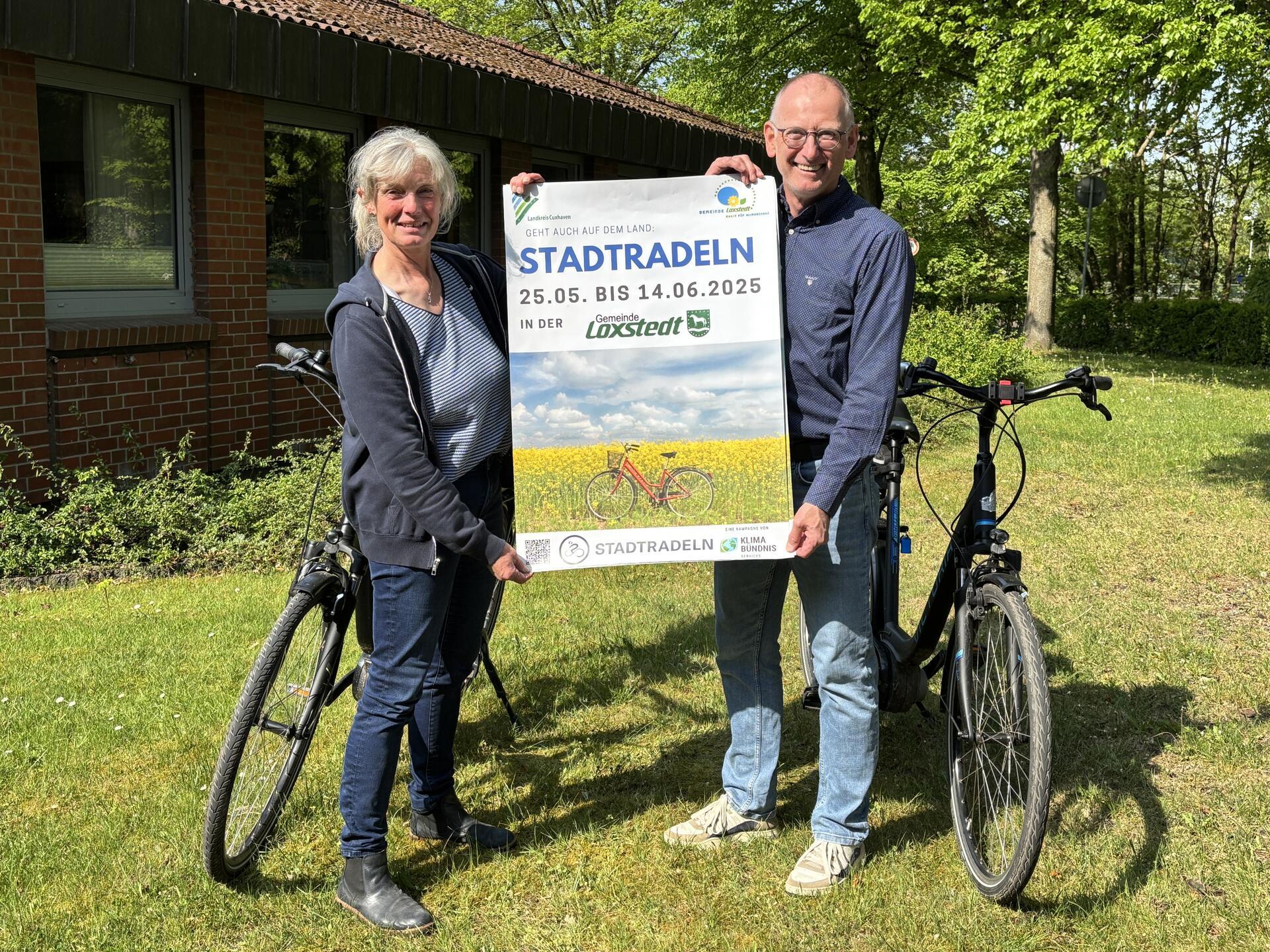 Eine Frau und ein Mann halten ein Plakat hoch, auf dem groß das Wort "Stadtradeln" zu lesen ist. Loxstedts Bürgermeister Detlef Wellbrock und Anne Böttjer, Klimaschutzmanagerin der Gemeinde Loxstedt, freuen sich schon auf den Start der diesjährigen Stadtradeln-Aktion und hoffen auf viele Mitradelnde.
