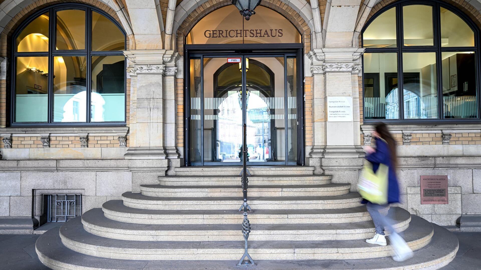 Gerichtsgebäude in Bremen, eine Frau geht die Treppen hoch. Am Landgericht Bremen beginnt am 7. Juli die Hauptverhandlung gegen vier Angeklagte. Ihnen wird unter anderem räuberische Erpressung in Bremerhaven vorgeworfen.