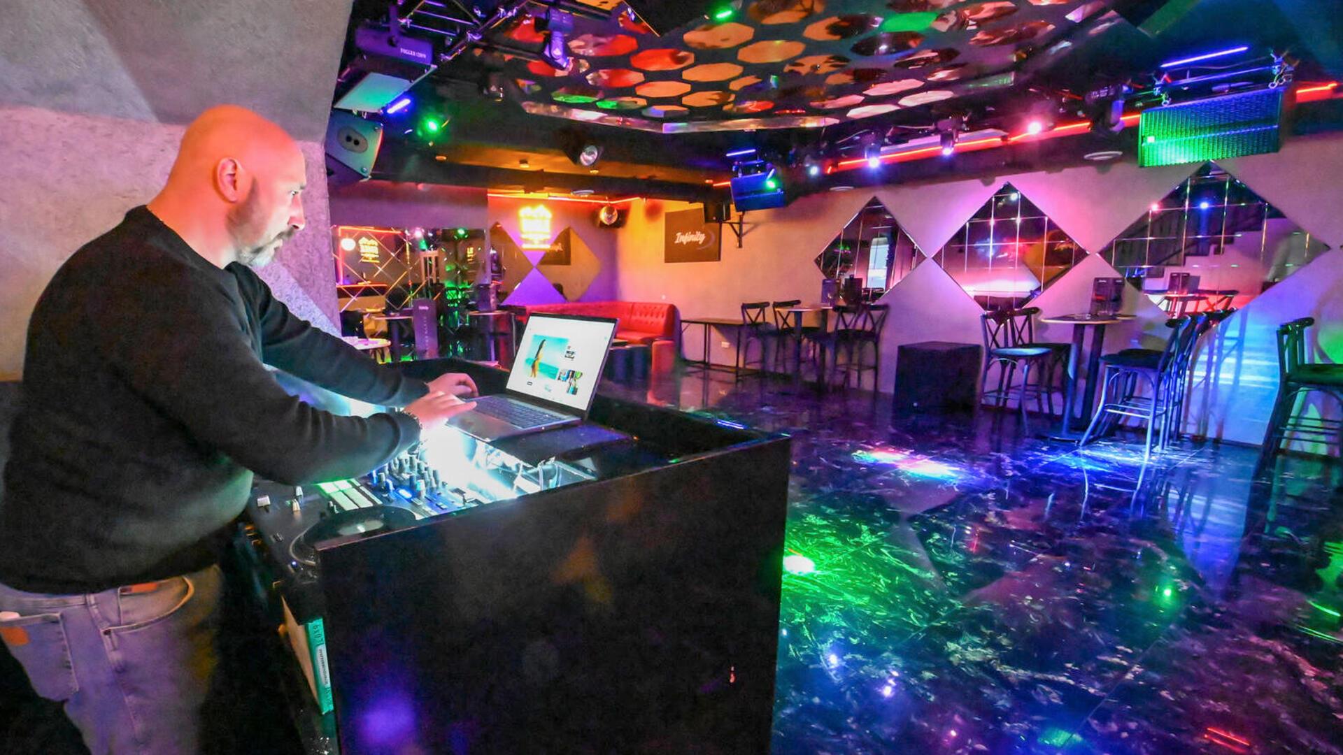 Ein Mann steht in einem leeren Club an einem DJ-Pult. Am Leher Bahnhof gibt es seit einigen Monaten den Club „Infinity“.