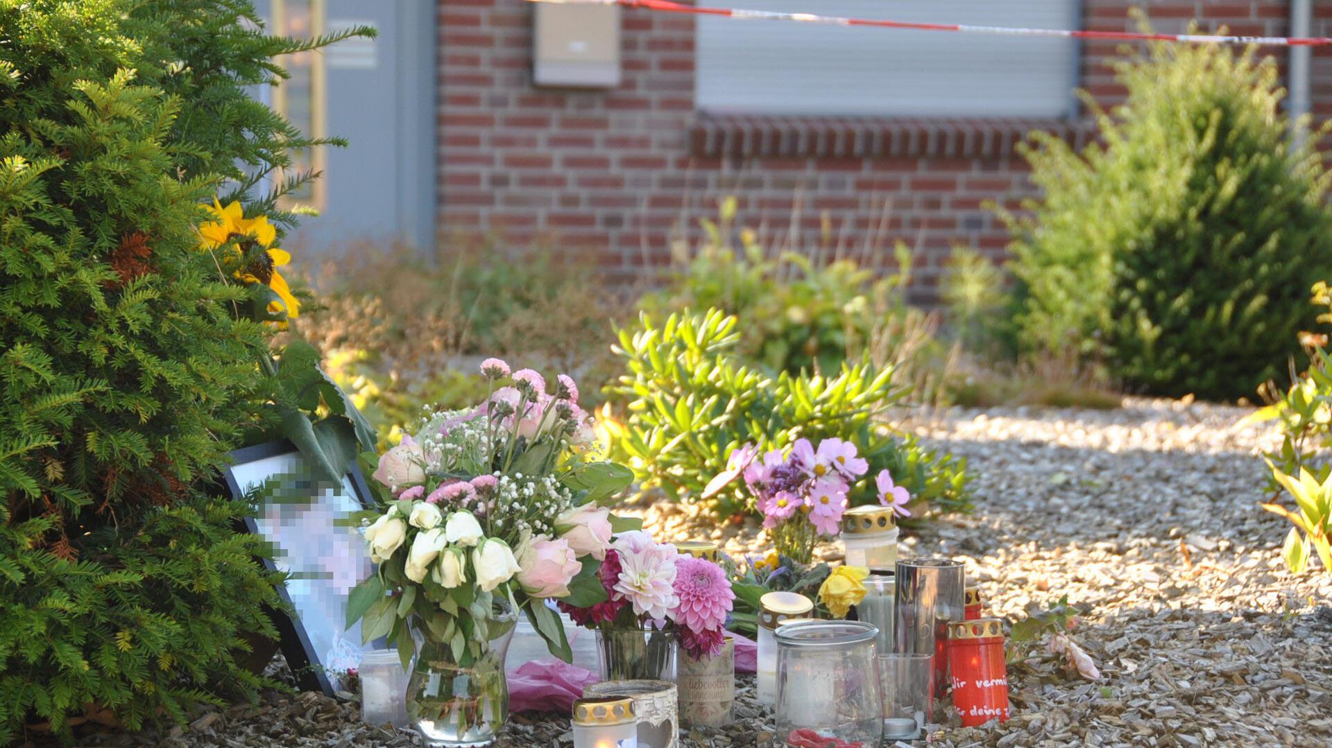 Am Sonntag stehen viele Blumen und Kerzen vor dem Haus in Gyhum am Hülsenbusch. Auch ein Foto der getöteten 30-Jährigen ist zu sehen, die Anteilnahme ist groß. 