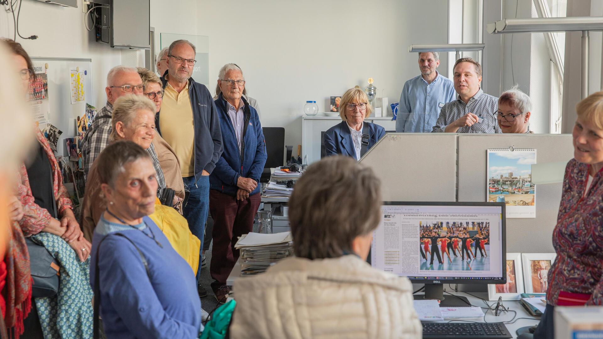 Viele Menschen stehen in einem Büro.
