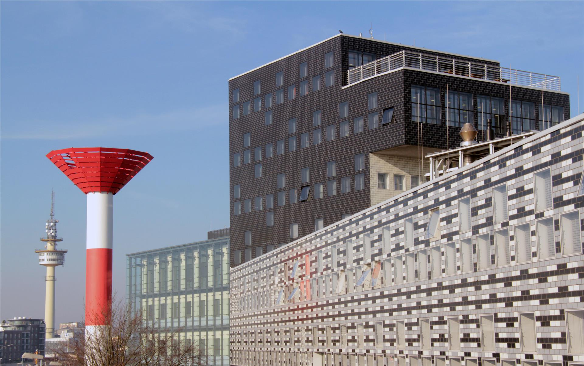 Ein Hochhaus, daneben ein Leuchtfeuer und ein Radarturm.