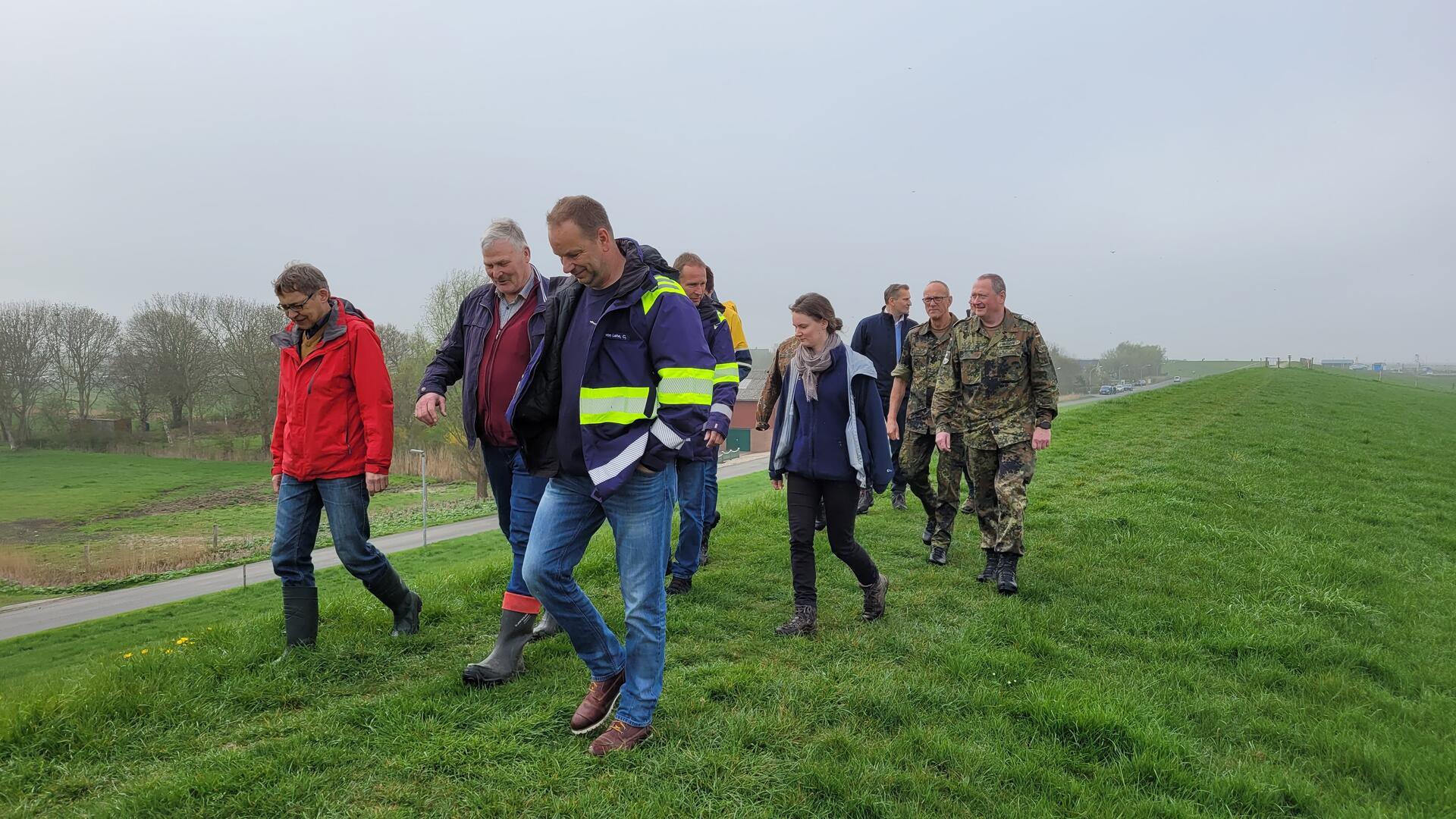 Andreas Lesch (links) vom Landkreis Cuxhaven nimmt den nördlichen Teil des Wurster Seedeichs gemeinsam mit den Vertretern von Deichverbänden, weiteren Behördenvertretern und der Bundeswehr unter die Lupe.