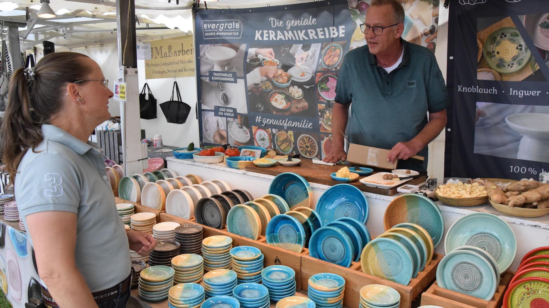 Kundin im Gespräch am Stand mit Keramikreiben.
