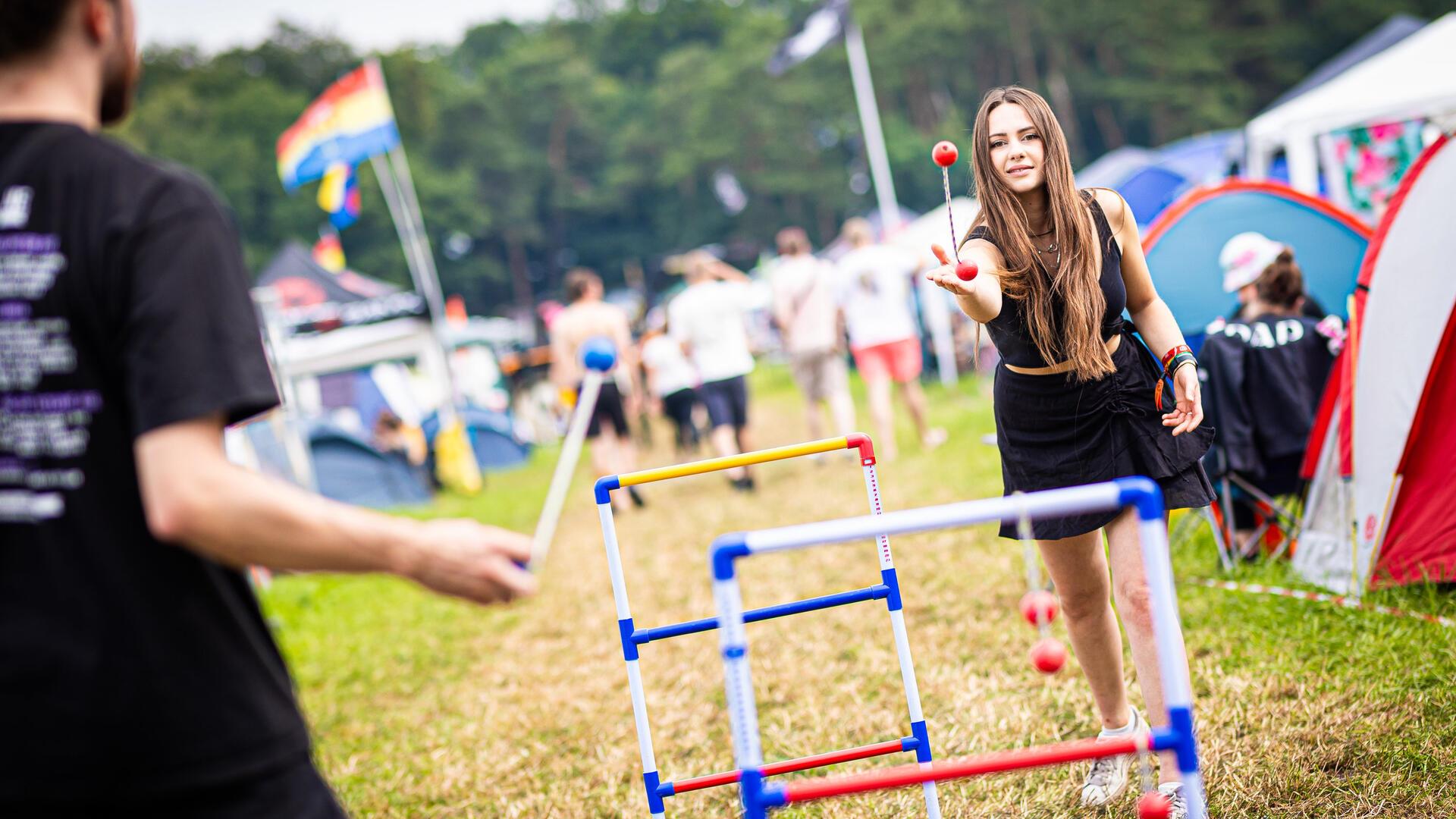 Erst Sonne, dann plötzlich Starkregen und Matsch: Der Hurricane-Freitag in Bildern Anna (r) spielt auf dem Zeltplatz des Hurricane Festivals ein Wurfspiel.