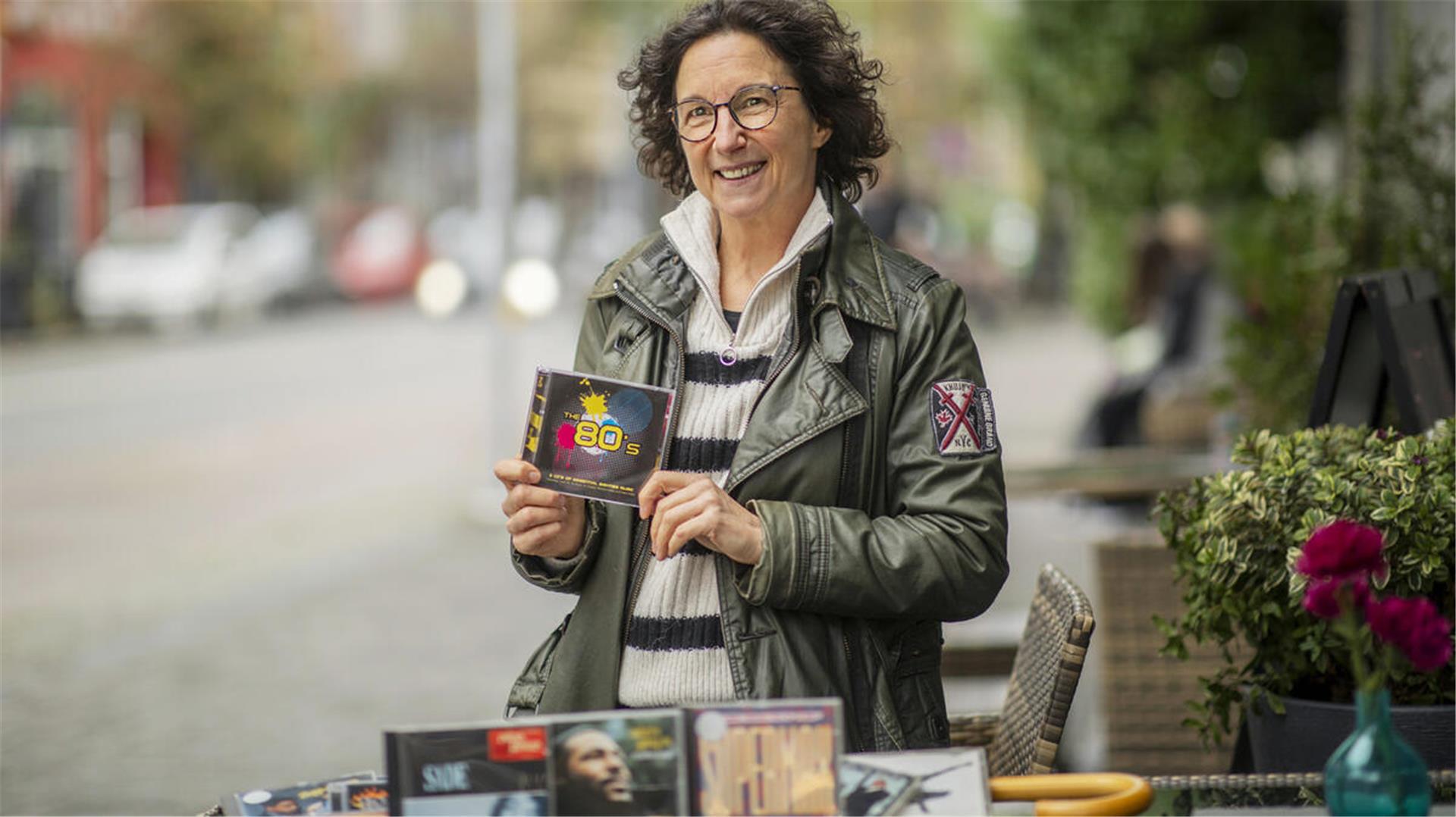 Eine Frau hält eine CD in der Hand.