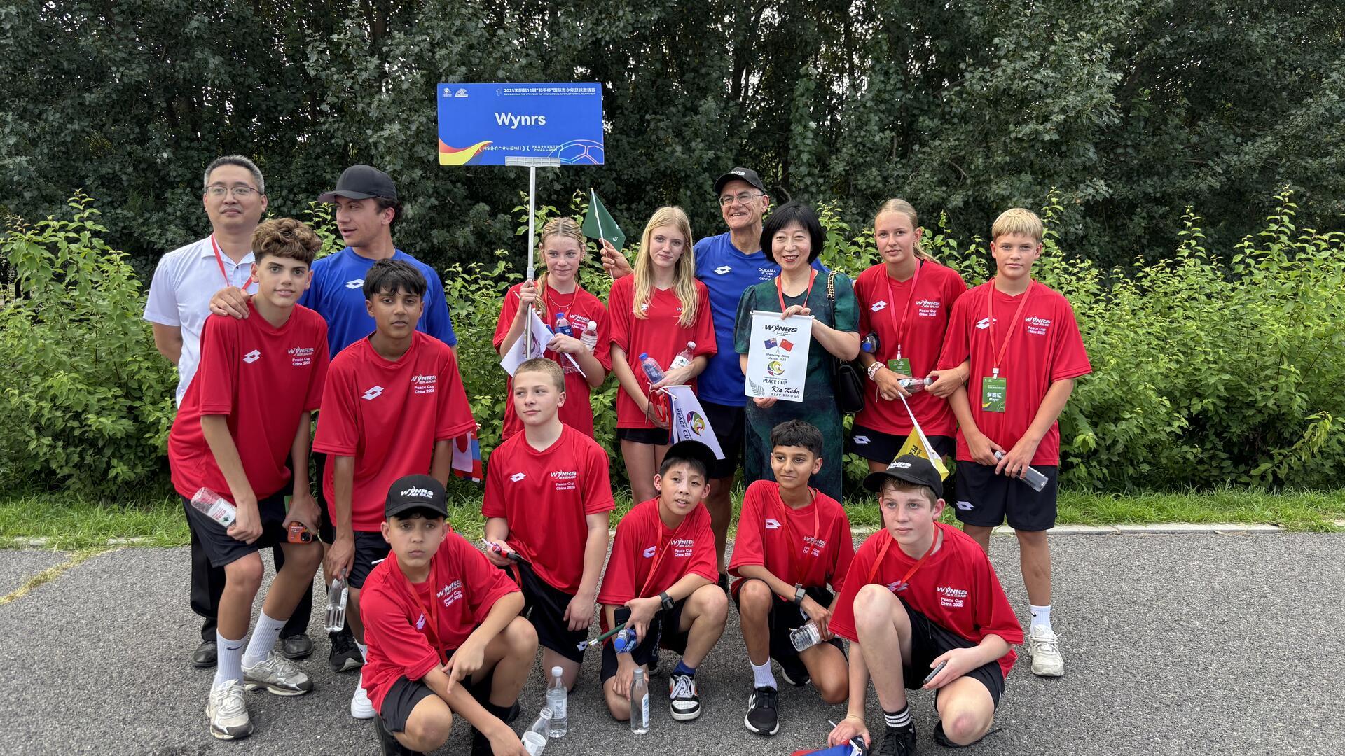 Anni und Johan Menke aus Wremen (stehend, rechts, 2. von re chts) kicken beim Peace Cup in China bei der neuseeländischen Mannschaft von Werder-Legende Wynton Rufer (4. von rechts) mit.