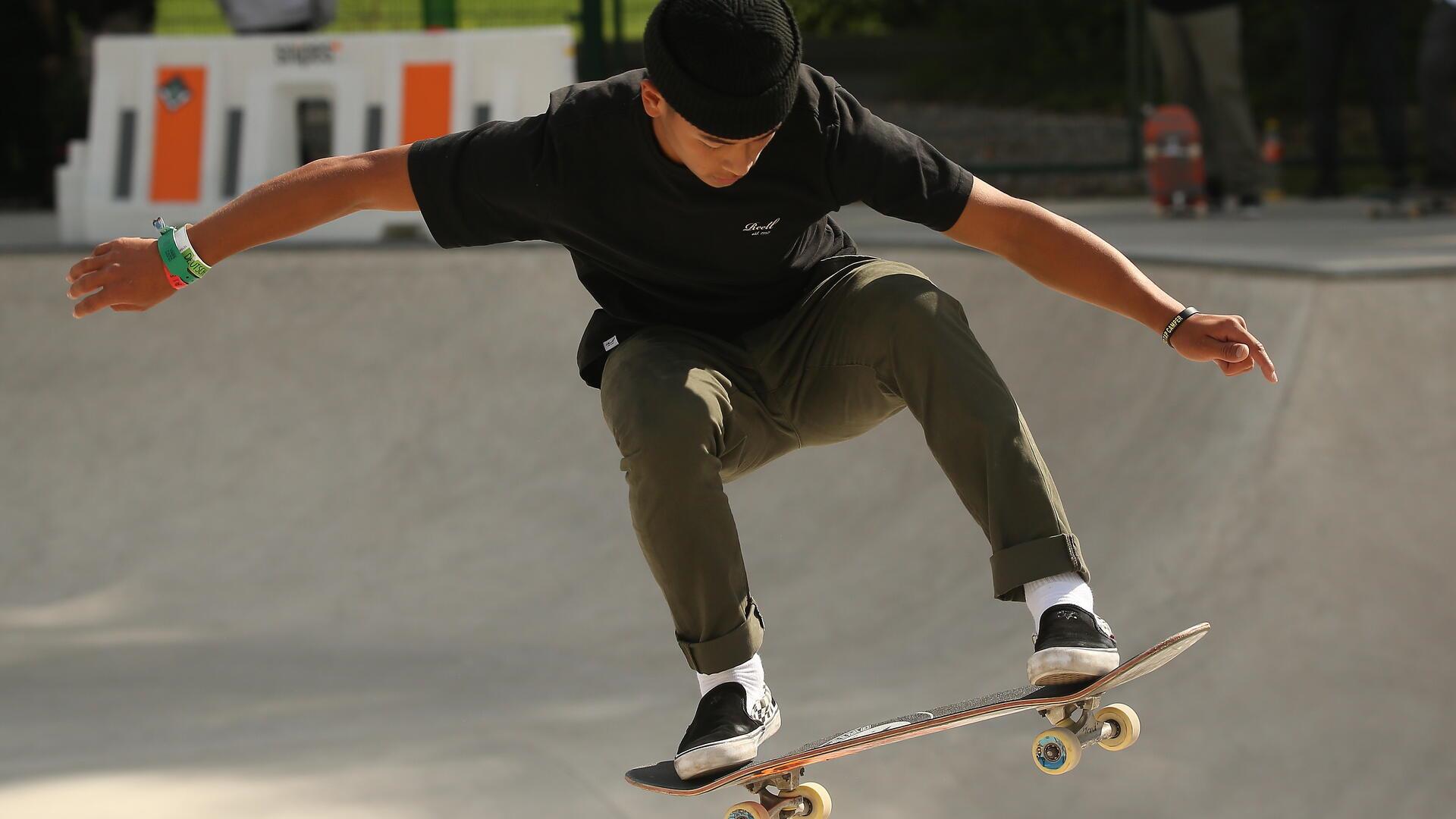Ein junger Mann zeigt einen Trick mit seinem Skateboard