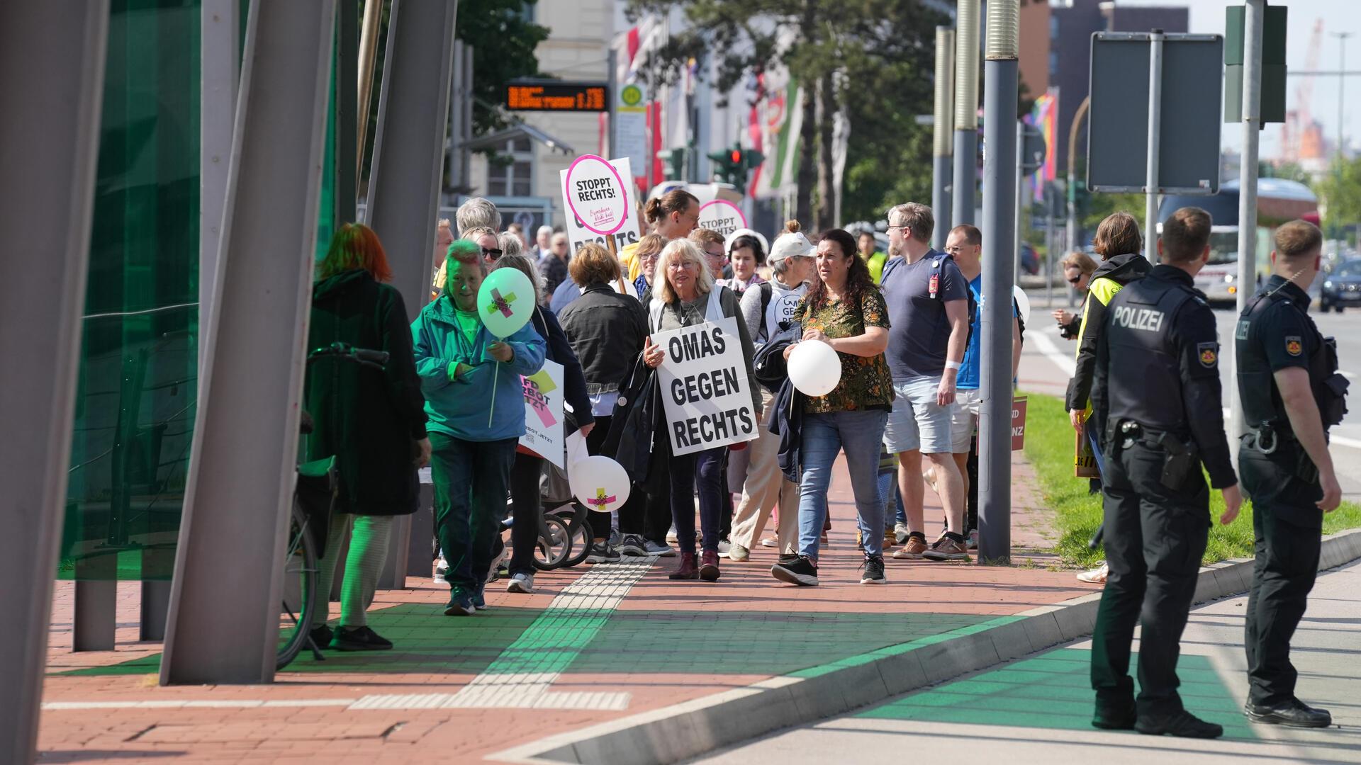 Eine Frau in einer Demo trägt ein Schild mit „Omas gegen Rechts“ .