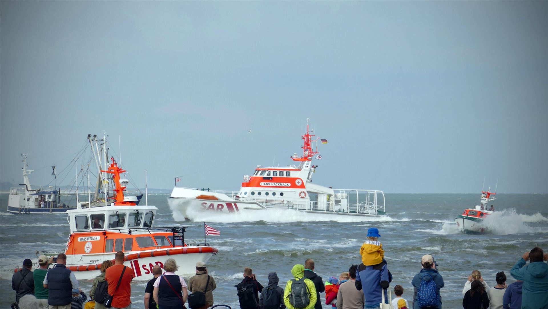 Zahlreiche Zuschauer beobachten von Land aus eine eindrucksvolle Vorführung der Seenotrettung auf See mit mehreren DGzRS-Rettungseinheiten, darunter die „Hans Hackmack“.