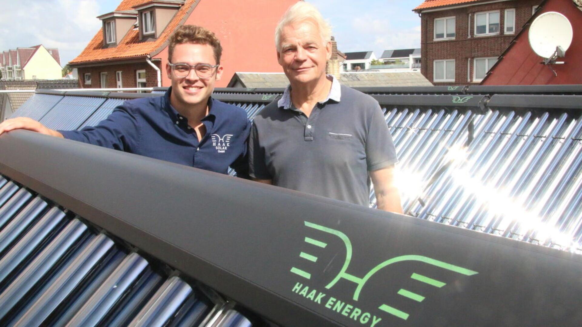 Zwei Männer stehen auf einem Dach mit 360 Vakuumröhren.