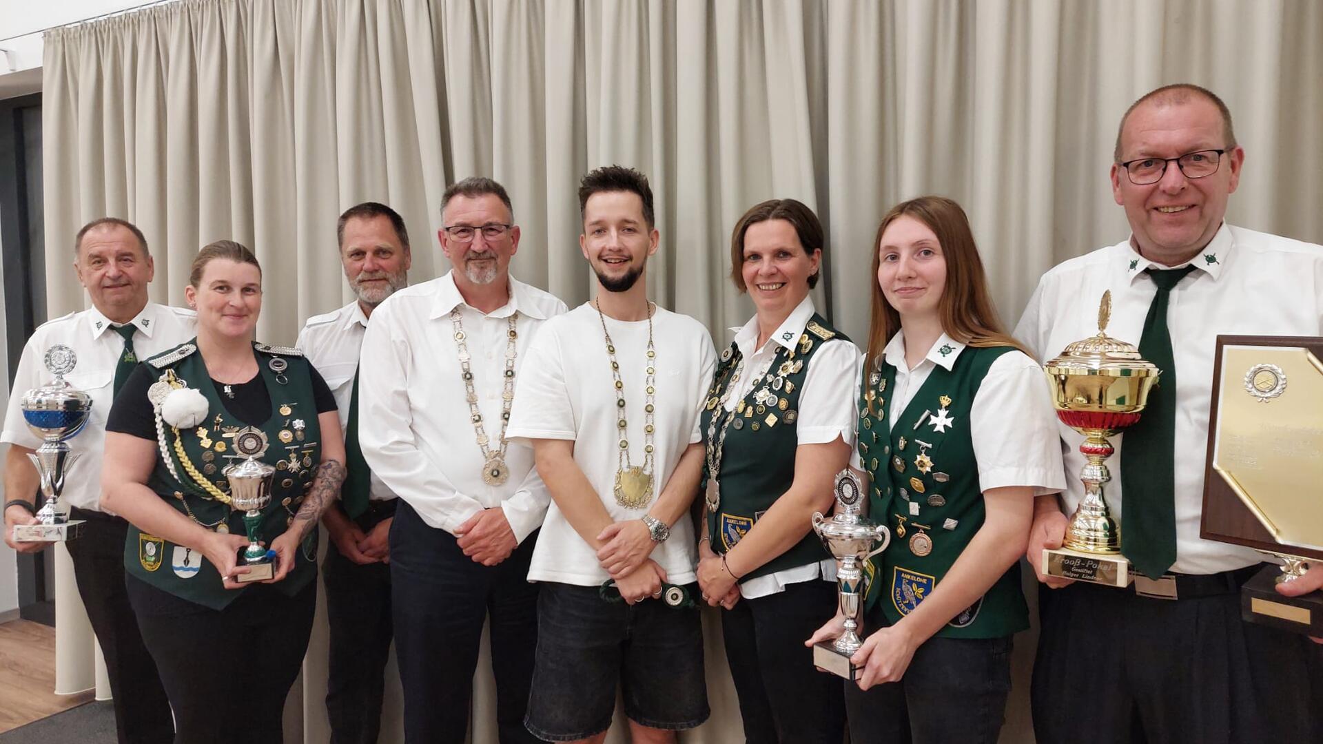 Männer und Frauen haben sich zum Gruppenbild aufgestellt.