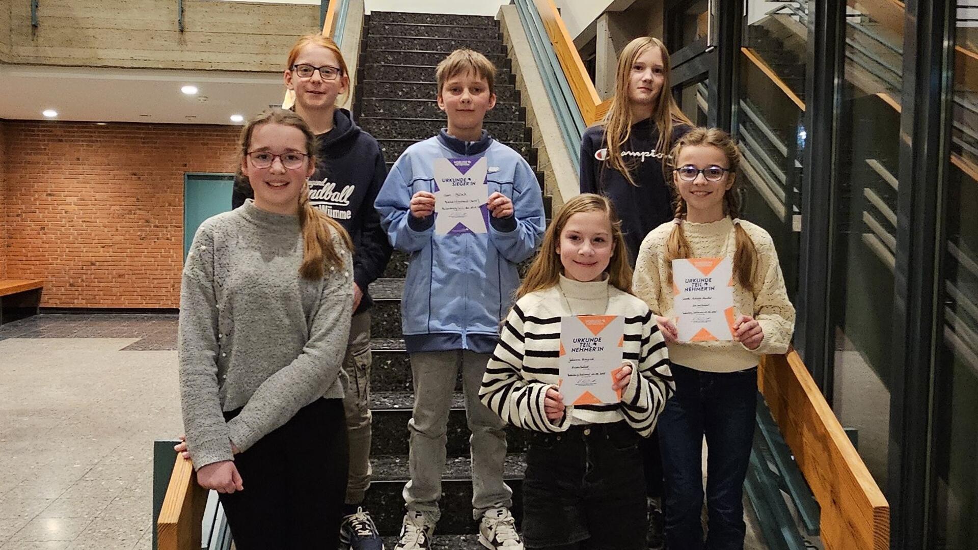 Sechs Kinder auf einer Treppe.