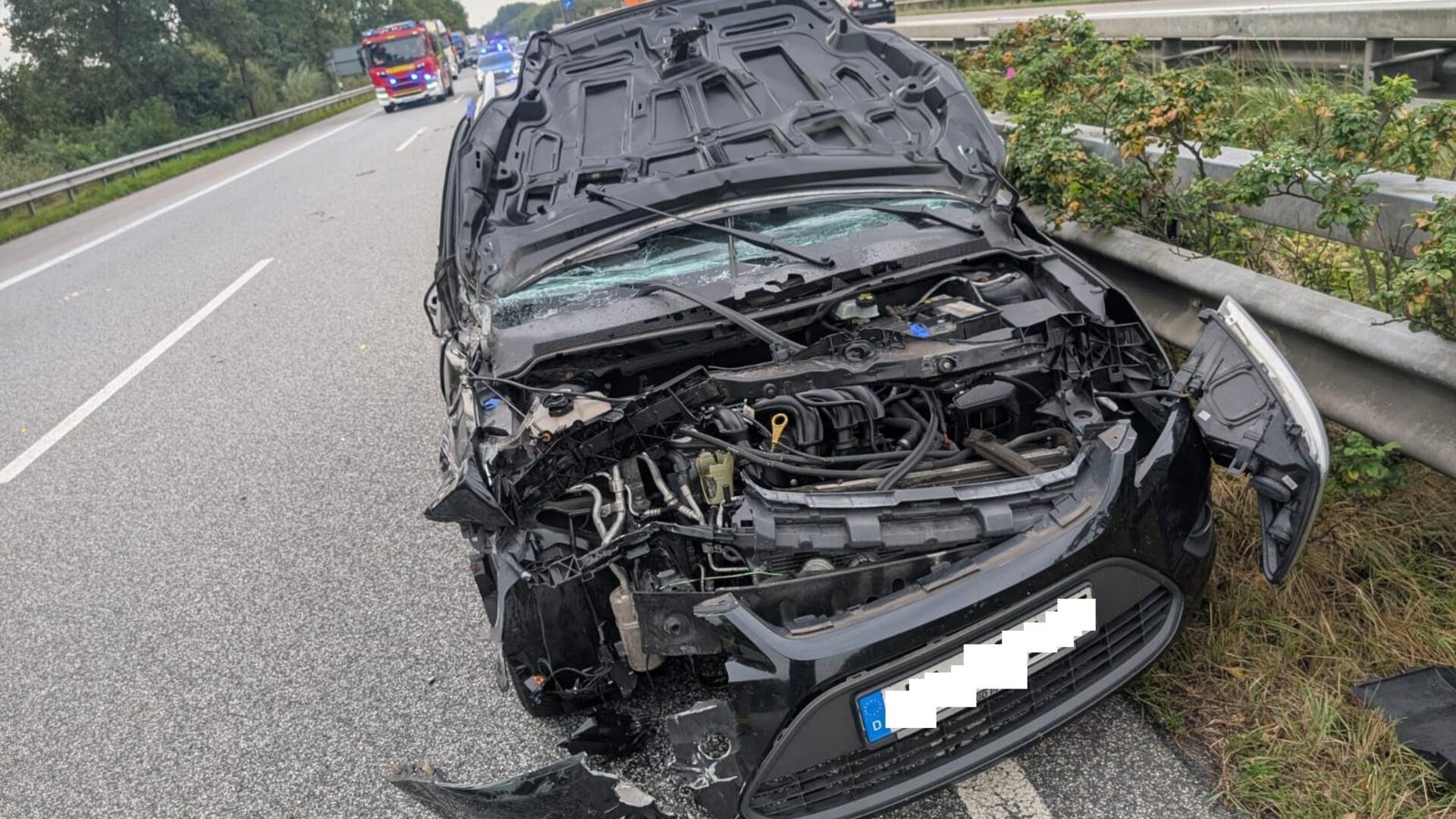 ein zerstörtes Auto steht nach einem Unfall auf einer Autobahn 
