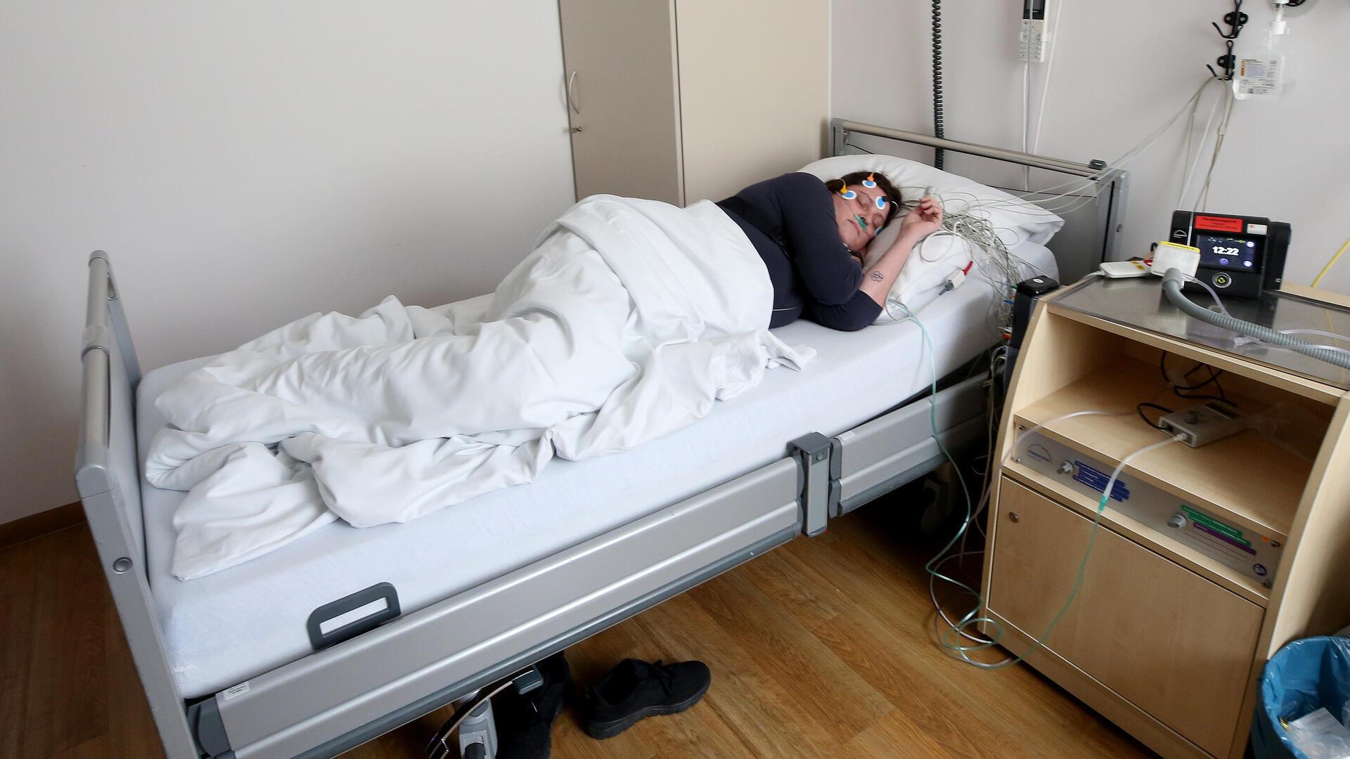  Eine Schlafpatientin liegt in einem Schlaflabor. 