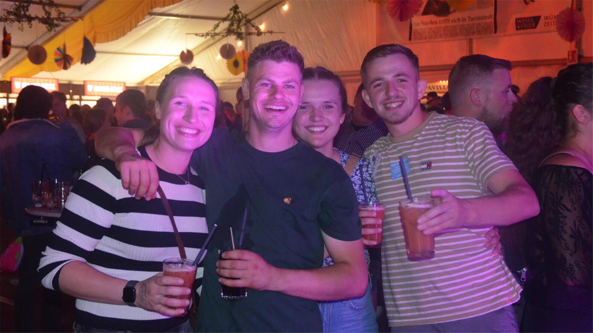 Eine Gruppe feiernder Menschen lacht in die Kamera.