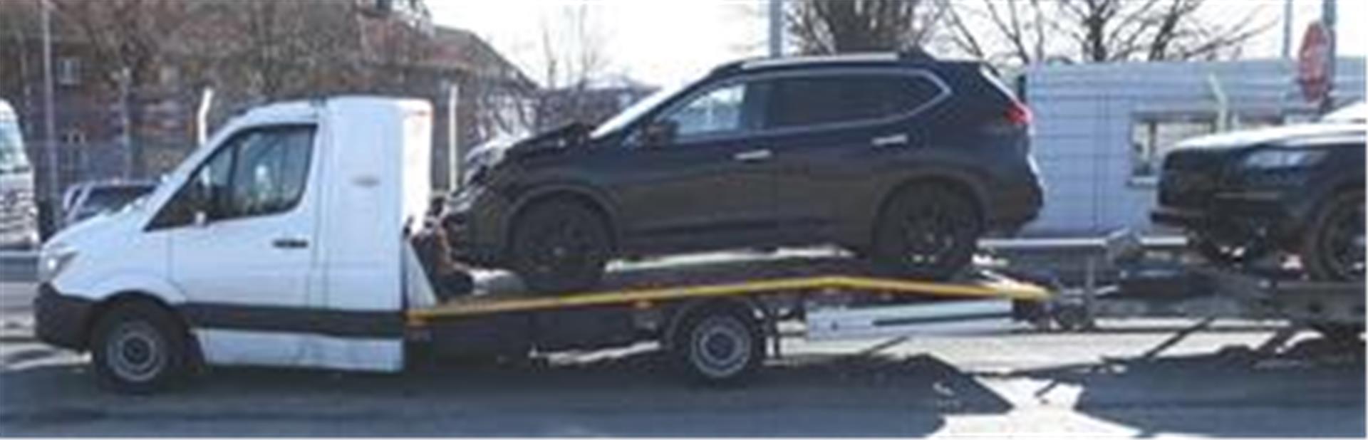 Ein Lkw, der mit einem Auto beladen ist und einen ebenfalls mit Auto beladenen Anhänger zieht. Der Lkw wurde von der Polizei wegen erheblicher Schäden aus dem Verkehr gezogen.