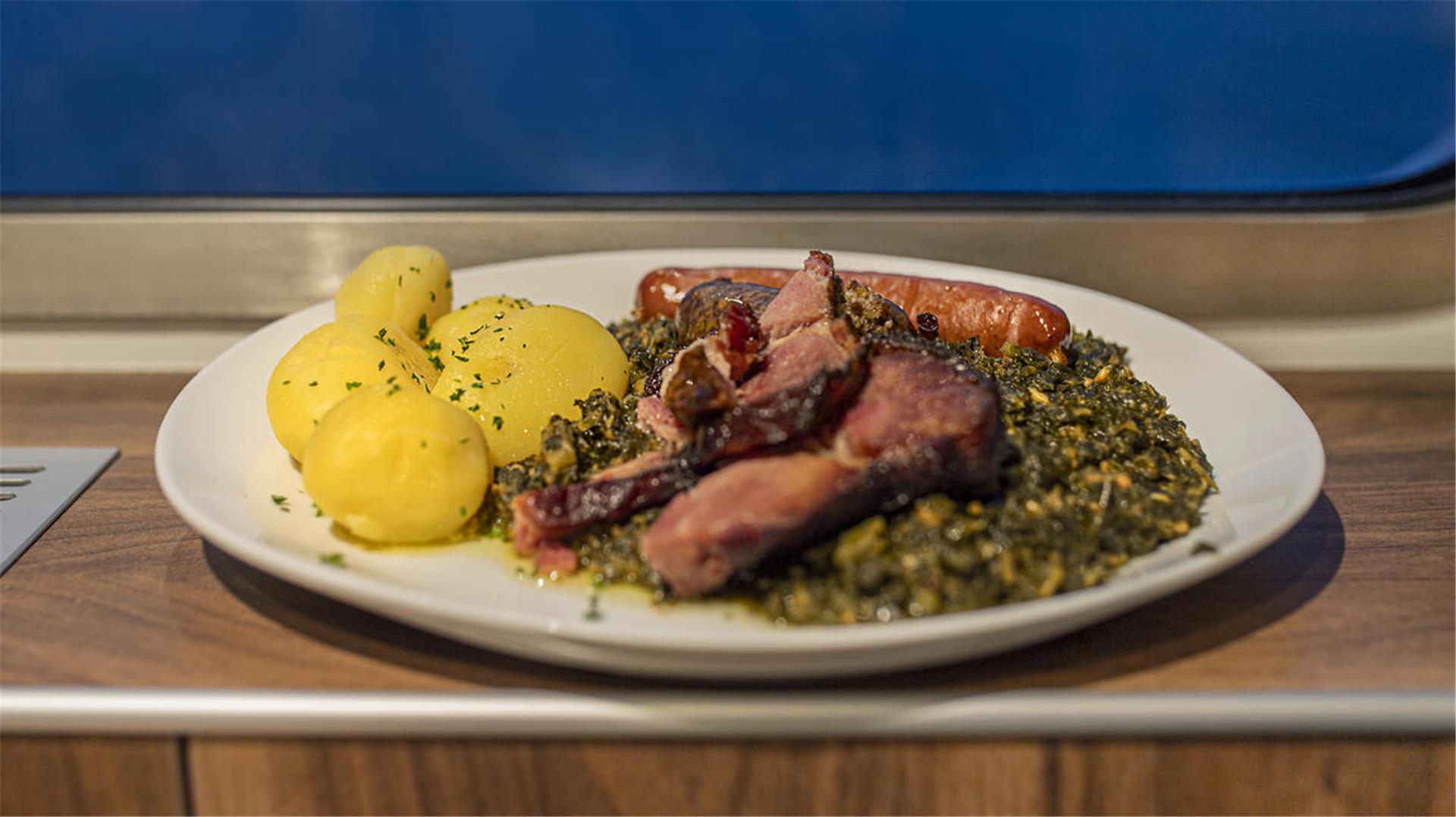Eine Portion Grünkohl mit Kartoffeln und Wurst. 