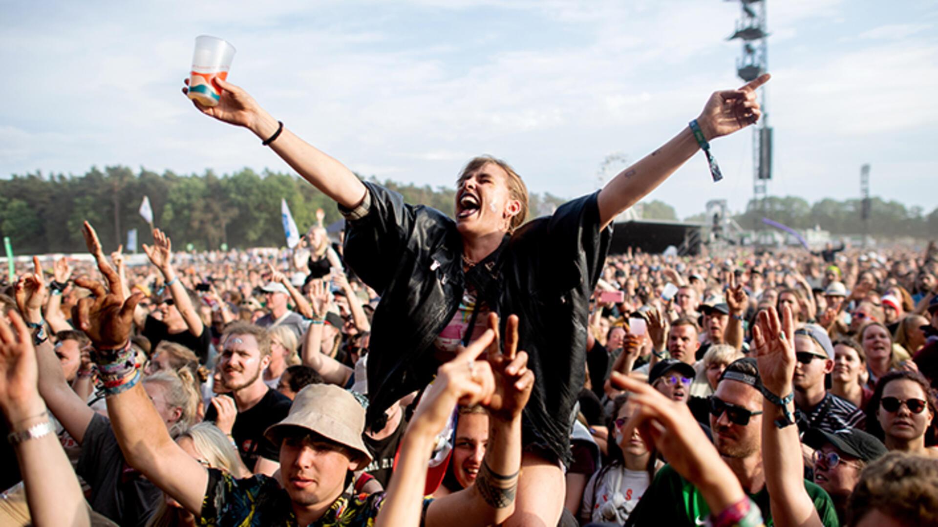 Ein Bild vom Hurricane Festival in Scheeßel. Eine Frau sitzt auf den Schultern eines Mannes und streckt die Arme von sich. Beim Hurricane-Festival in Scheeßel sollen auch Musikfans Spaß haben, die wegen einer Behinderung auf Unterstützung angewiesen sind.