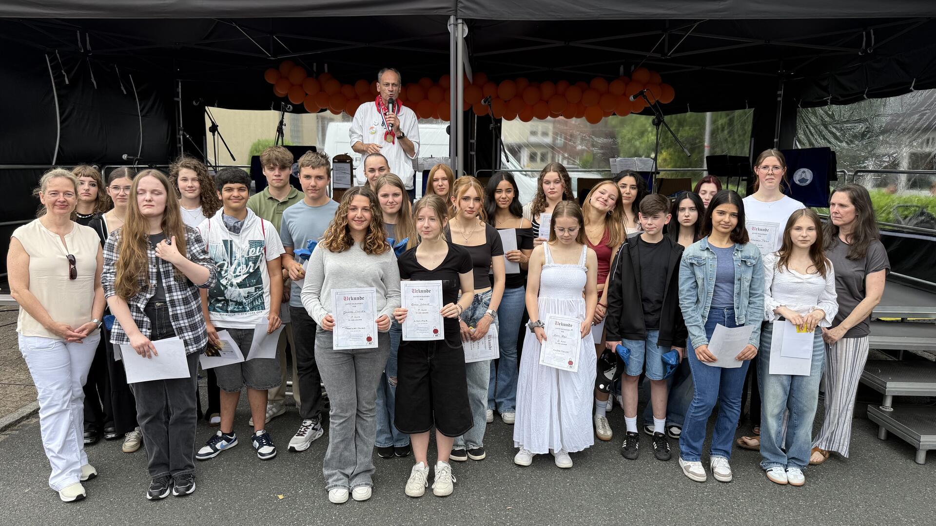 Gruppenfoto mit vielen Künstlern. Beim Matjesfest wurden die Gewinnerinnen und Gewinner von „Kunst im Rahmen“ geehrt. Die besten Werke zeigt jetzt die Volksbank Zeven.