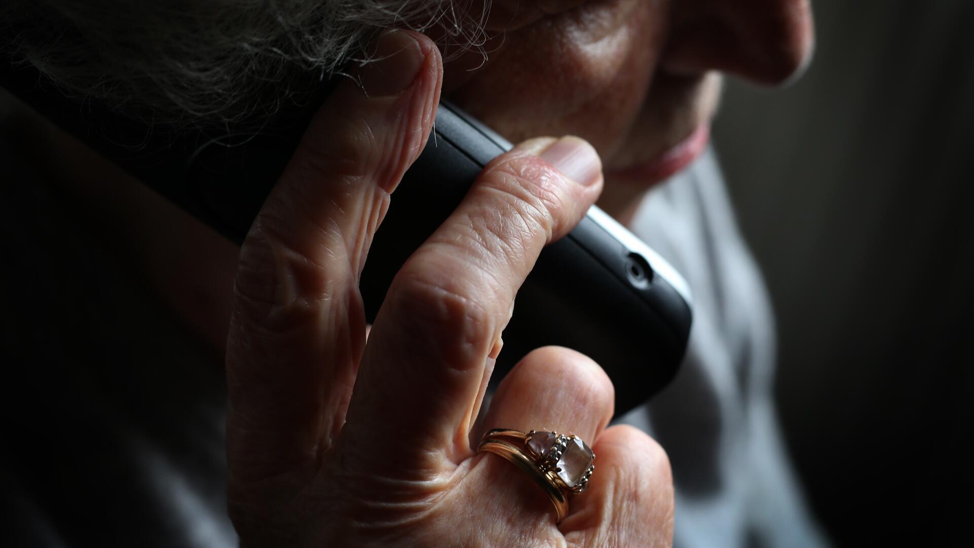 Eine ältere Frau telefoniert mit einem schnurlosen Festnetztelefon