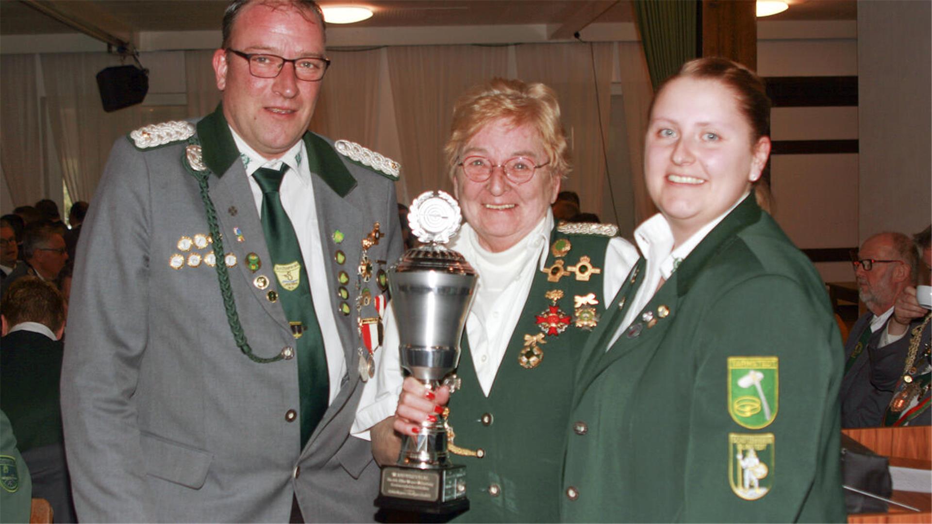 Bezirksdamensportleiterin Melanie Bockhorn (rechts) überreichte den Siegerpokal dem stellvertretenden Präsidenten des SK Unterelbe Maik Treuel und der Geschäftsführerin Uschi Gimm.