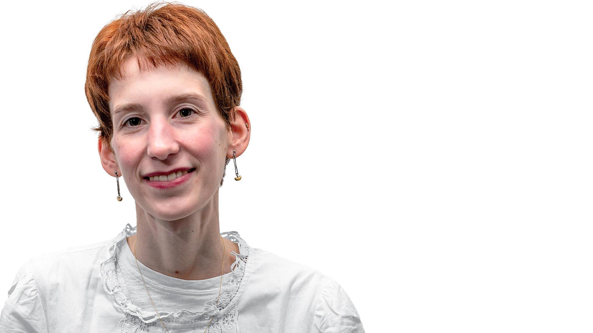Frau mit kurzen roten Haaren lächelt in Kamera