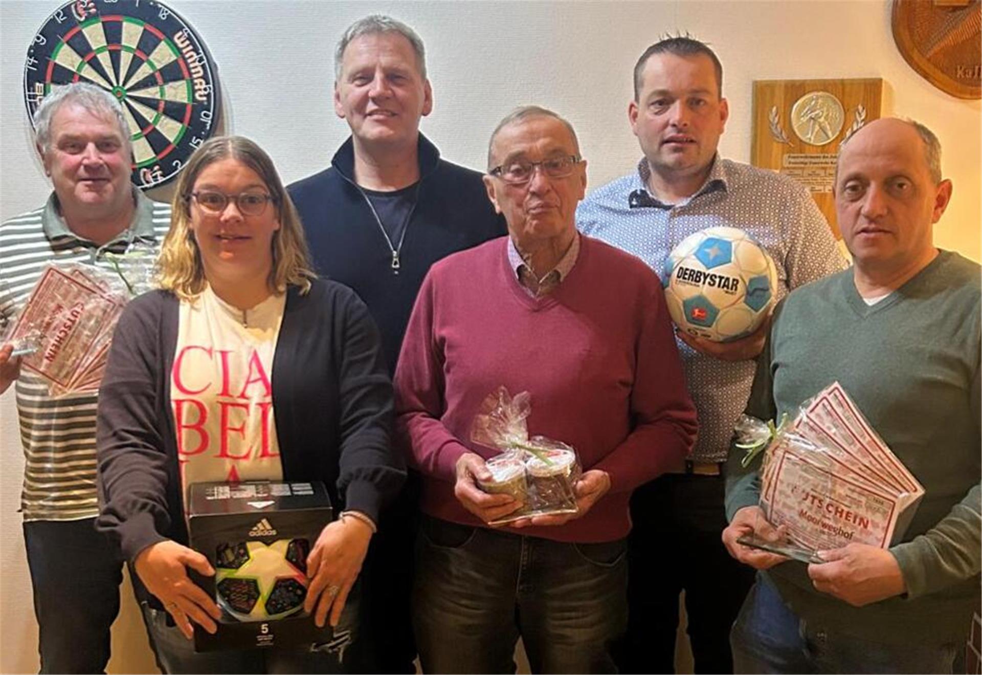 Eine Frau und fünf Männer stehen als Gruppe zusammen