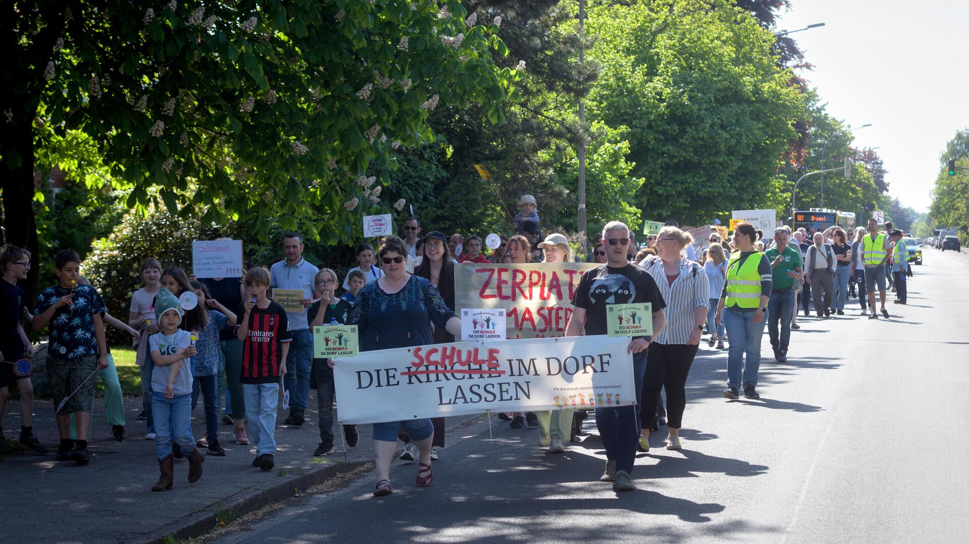 Menschen protestieren mit Schildern.