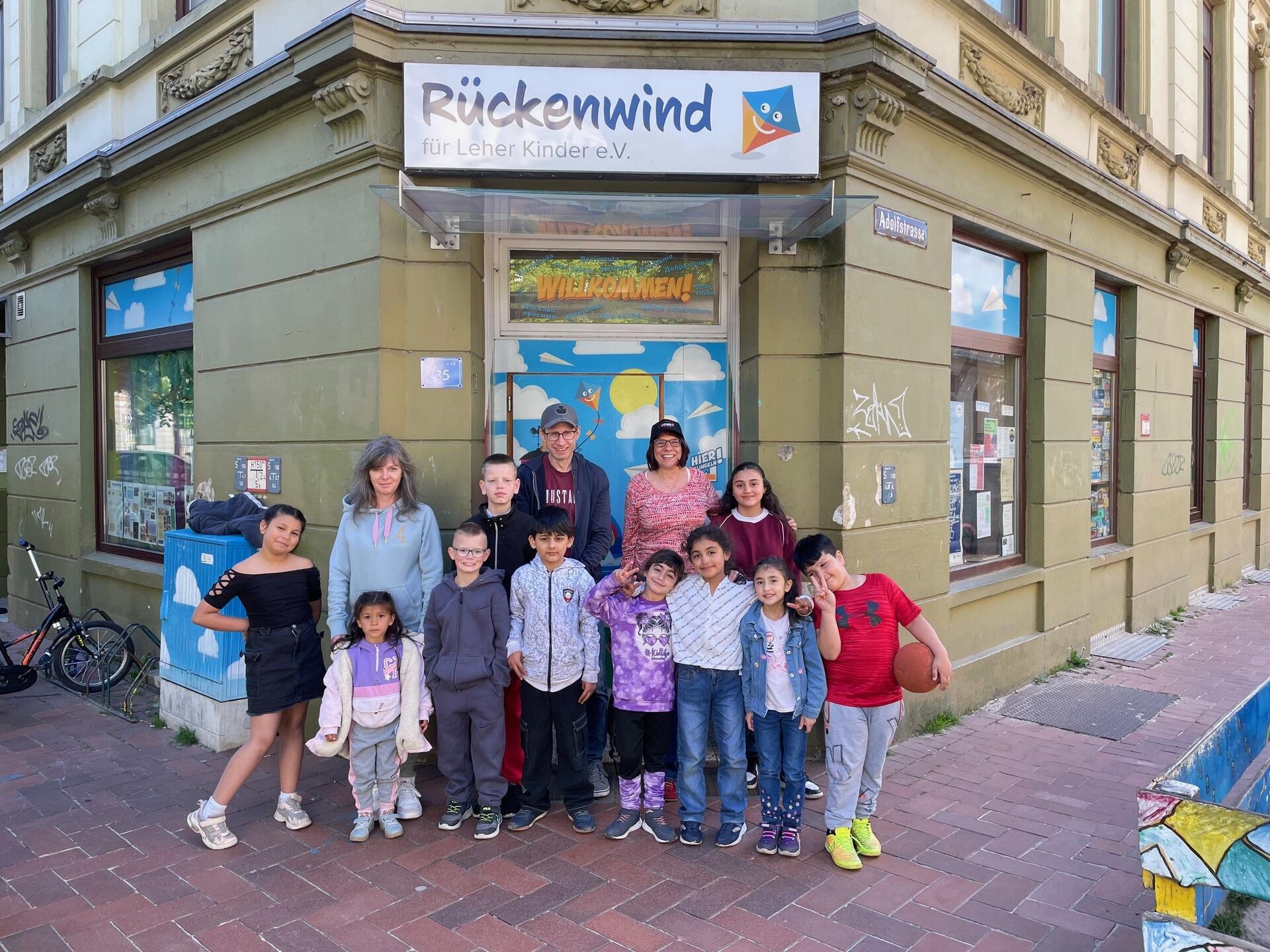 Kinder und Erwachsene stehen vor der Eingangstür des Projektes Rückenwind.