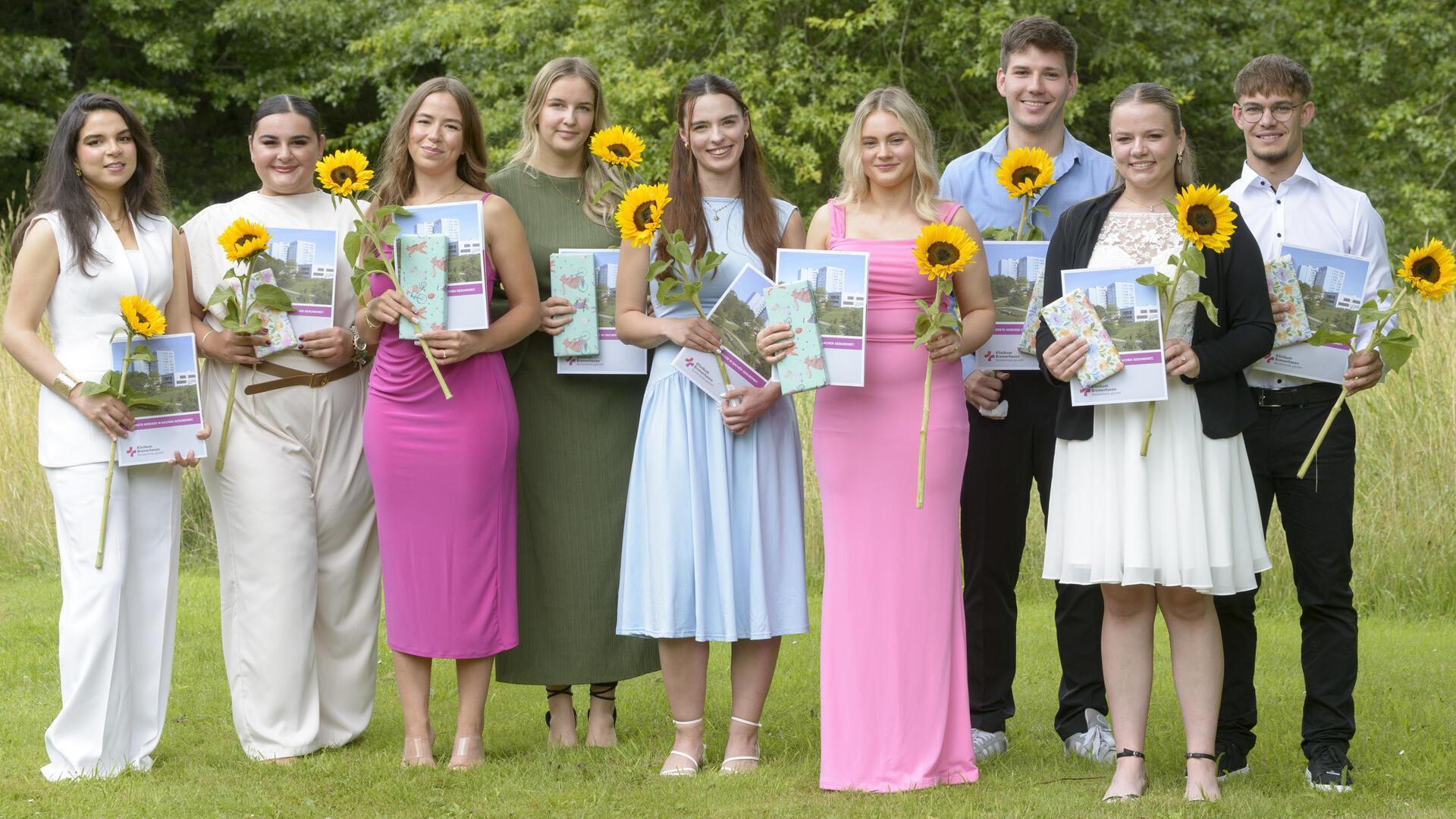 Sieben Frauen und zwei Männer haben sich zum Erinnerungsfoto aufgestellt. In den Händen hält jeder eine Urkunde und eine Sonnenblume.