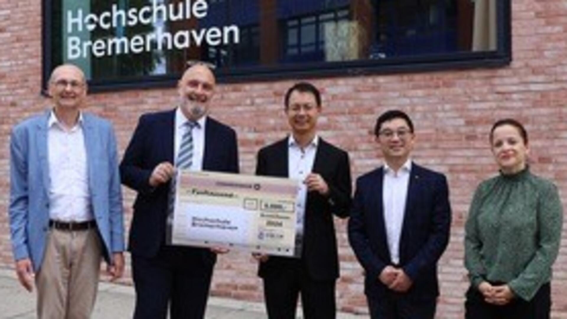 Fünf Personen mit einem Scheck
