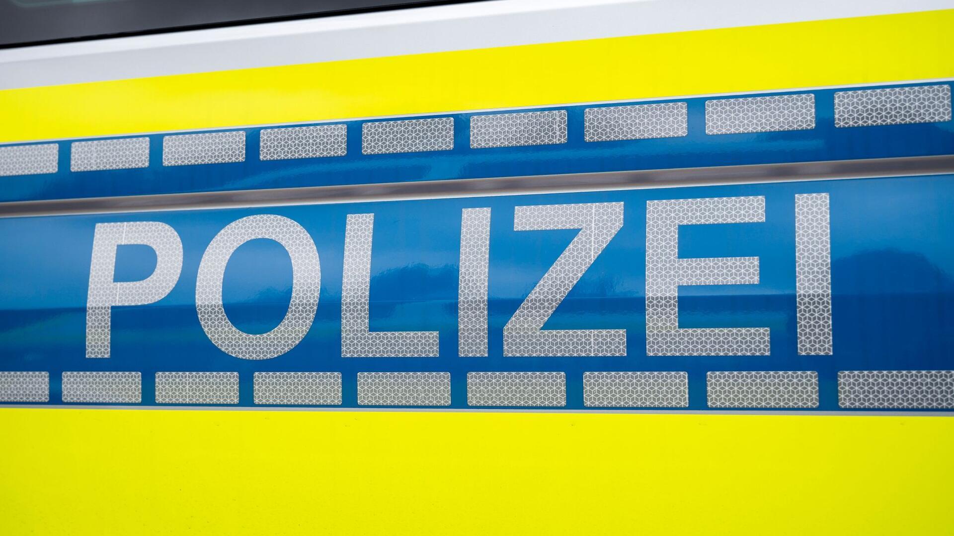 Der Schriftzug "Polizei" auf blauem Hintergrund und zwei gelbe Streifen oben und unten.
