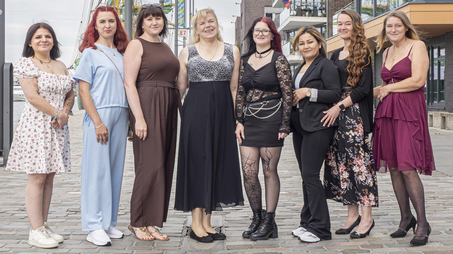 Acht Frauen stehen nebeneinander.