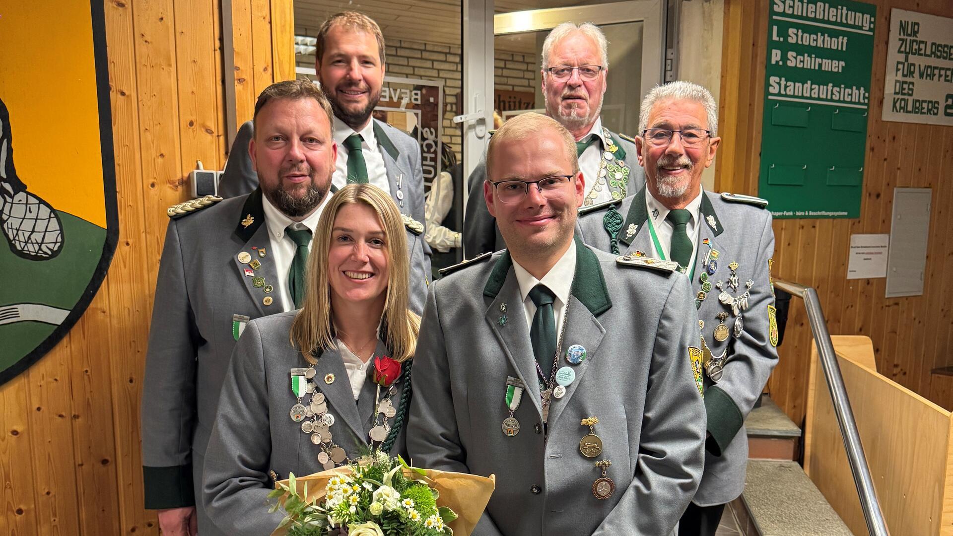 Die neuen Würdenträger des Schützenvereins Beverstedt stehen in Uniform zusammen, vorne eine Frau mit Blumenstrauß und ein Mann mit Schützenorden.