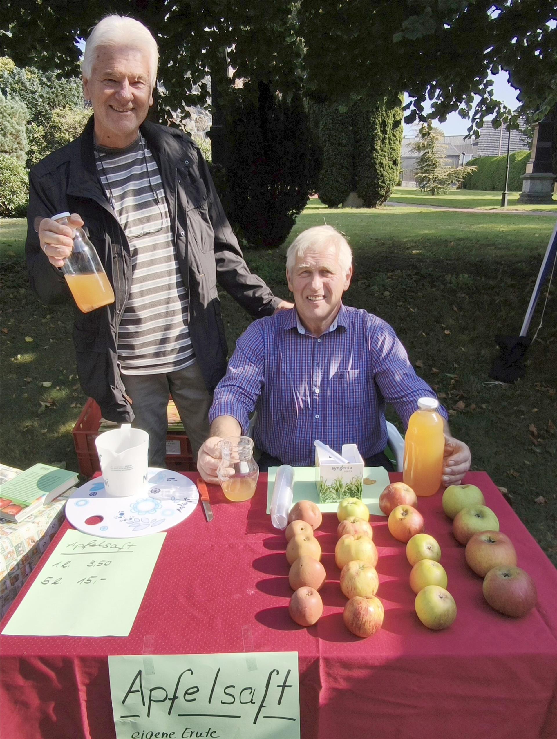 zwei Männer mit Äpfeln und Saft