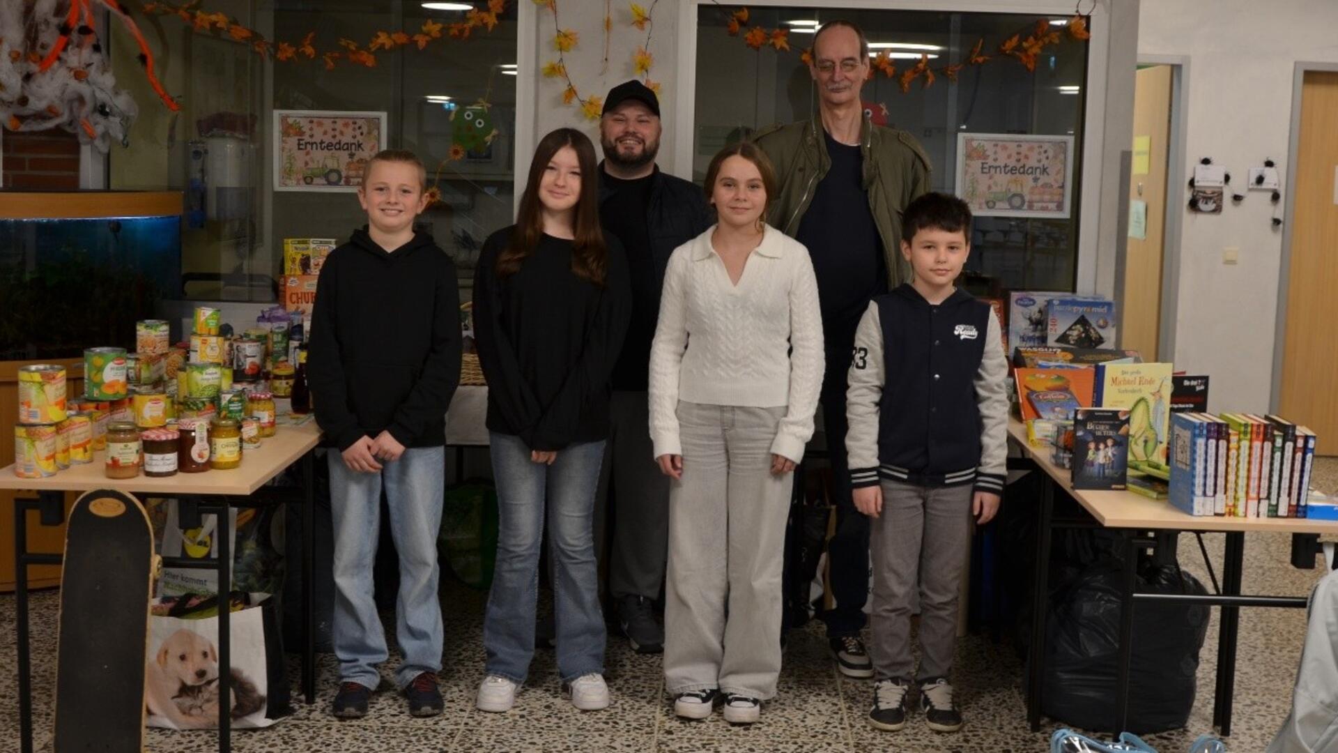 Schülerinnen und Schüler stehen vor Tischen mit Spenden 