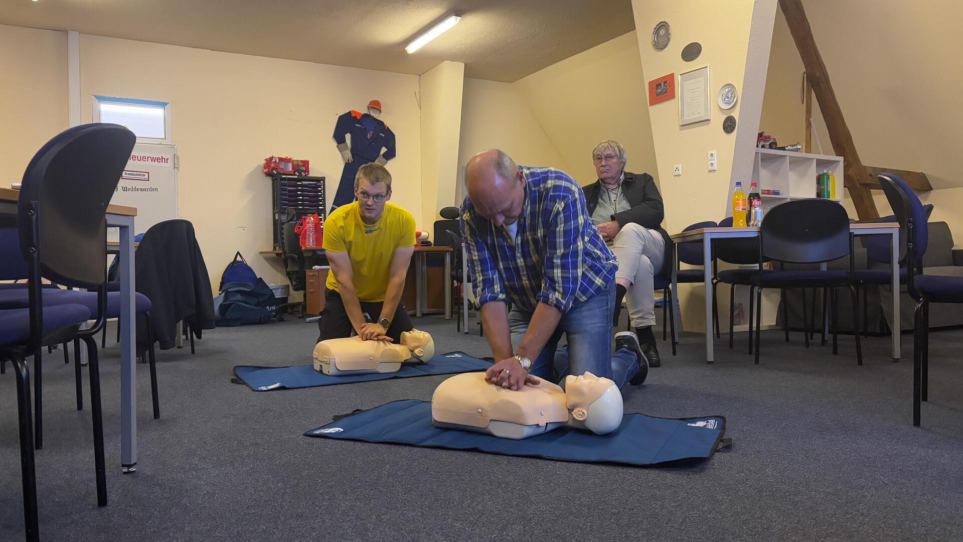 Bei einem Erste-Hilfe-Kursus üben zwei Teilnehmer die Herzdruckmassage an Puppen.
