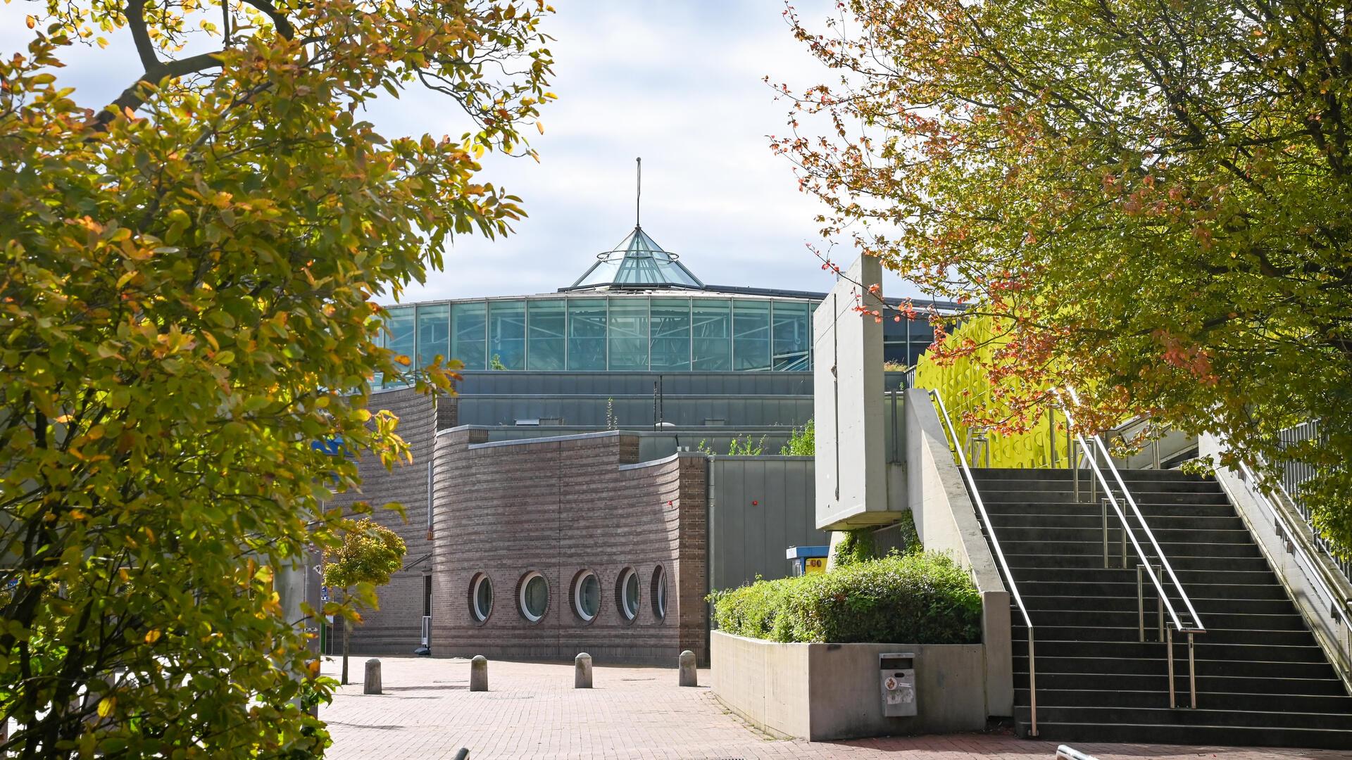 Stadthallengebäude mit Bäumen.