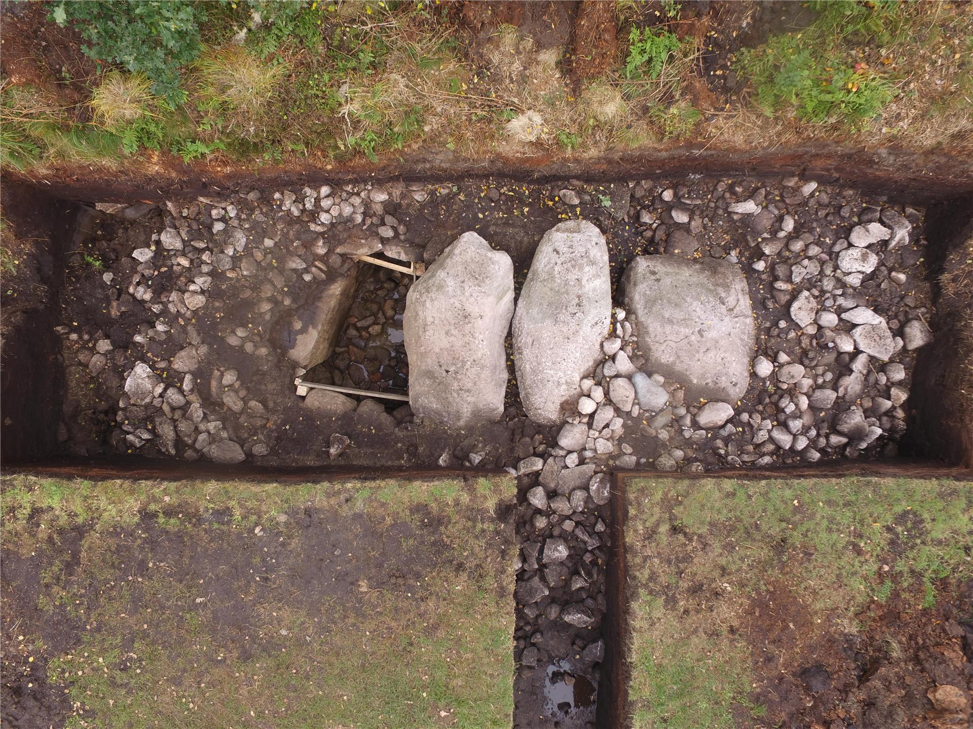 Blick auf eine archäologische Grabung mit freigelegten Steinen und Strukturen – ihre genaue Funktion wird im Rahmen der Untersuchung erforscht.