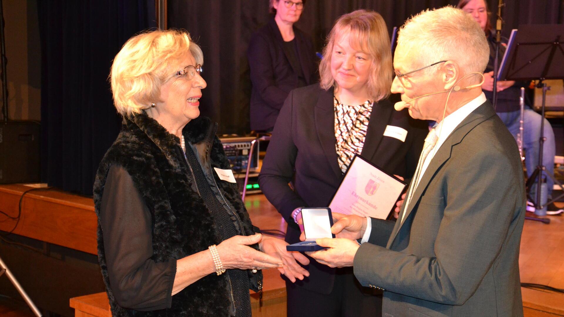 Brigitte Hopff wird als Bürgerpreisträgerin 2025 von Bürgermeister Jens Petersen und seiner Stellvertreterin Martina Stelljes mit Medaille und Urkunde geehrt.
