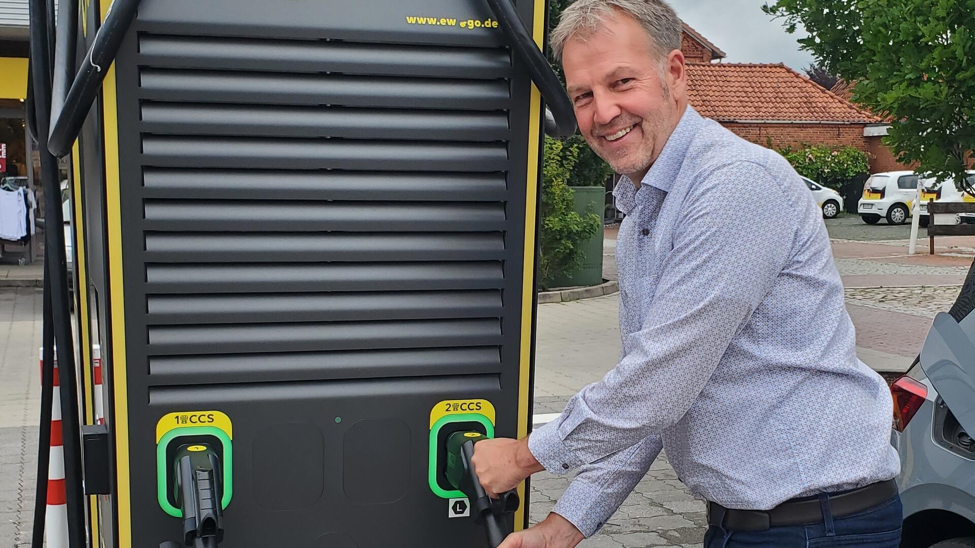 Der Beverstedter Bürgermeister Guido Dieckmann steht vor einer Schnellladestation in Beverstedt. 