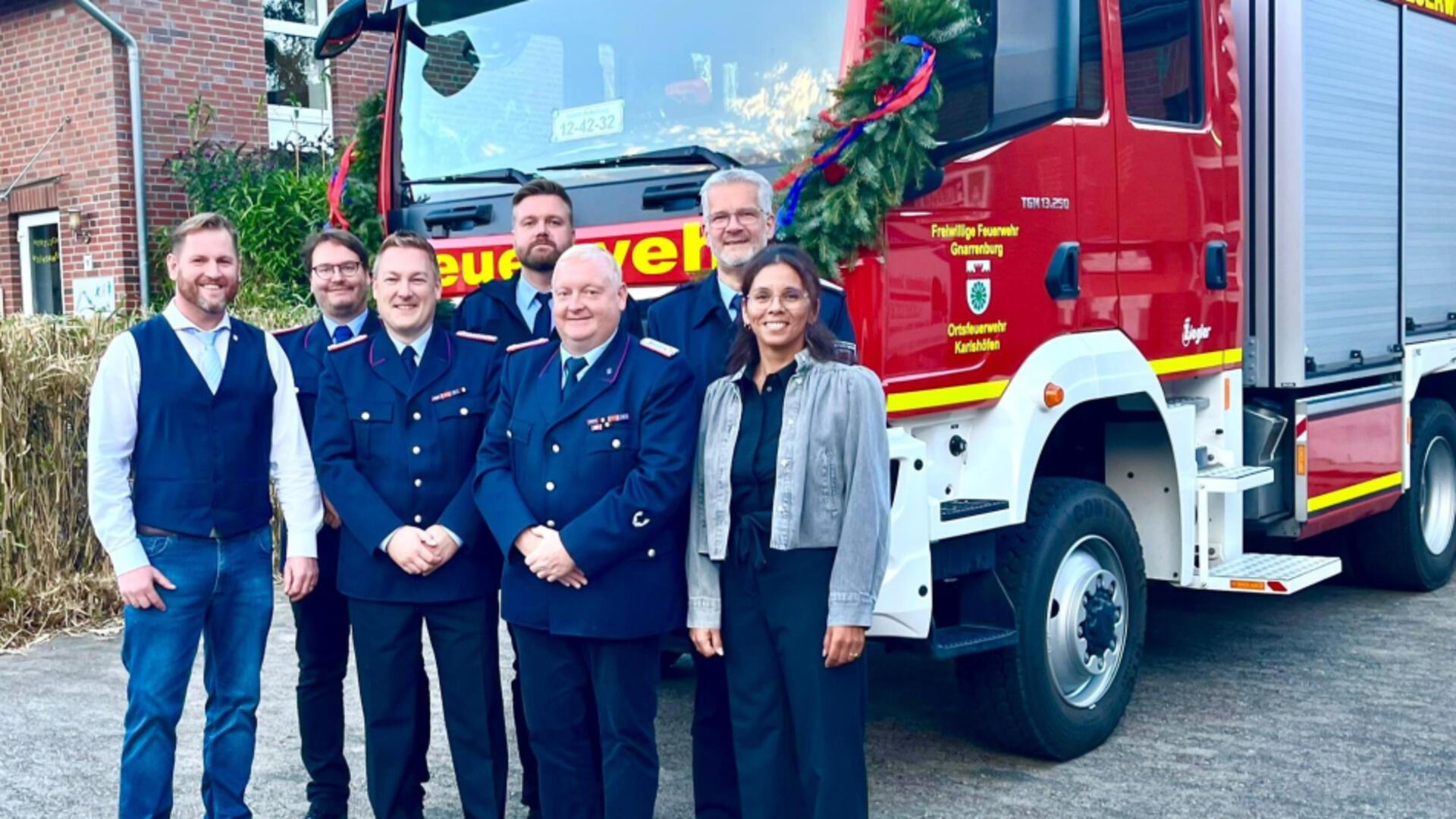 Bürgermeister Marc Breitenfeld (links) übergibt der Feuerwehr Karlshöfen das neue Fahrzeug an Ortsbrandmeister Marco Teetz (vorne, Zweiter von rechts).
