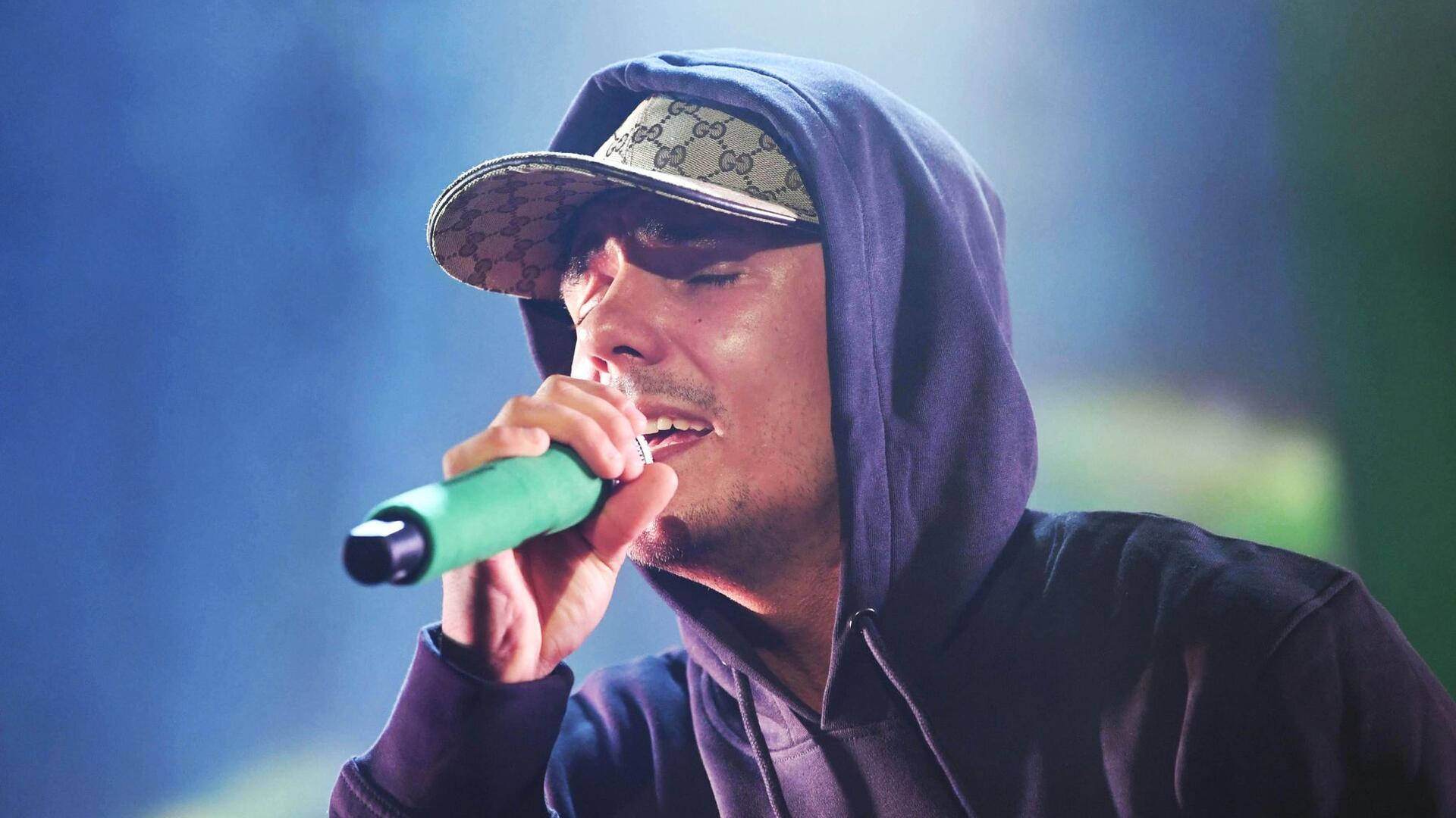 Der deutsche Rapper Capital Bra singt auf einer Bühne.