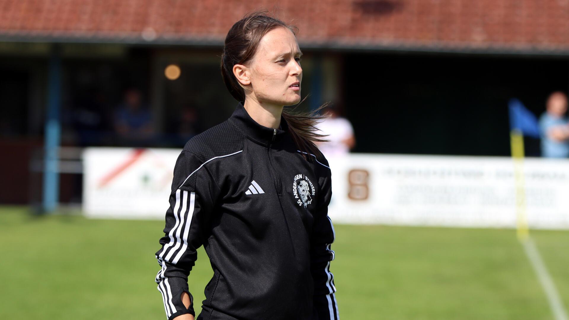 Eine Frau in einem schwarzen Trainingsanzug.