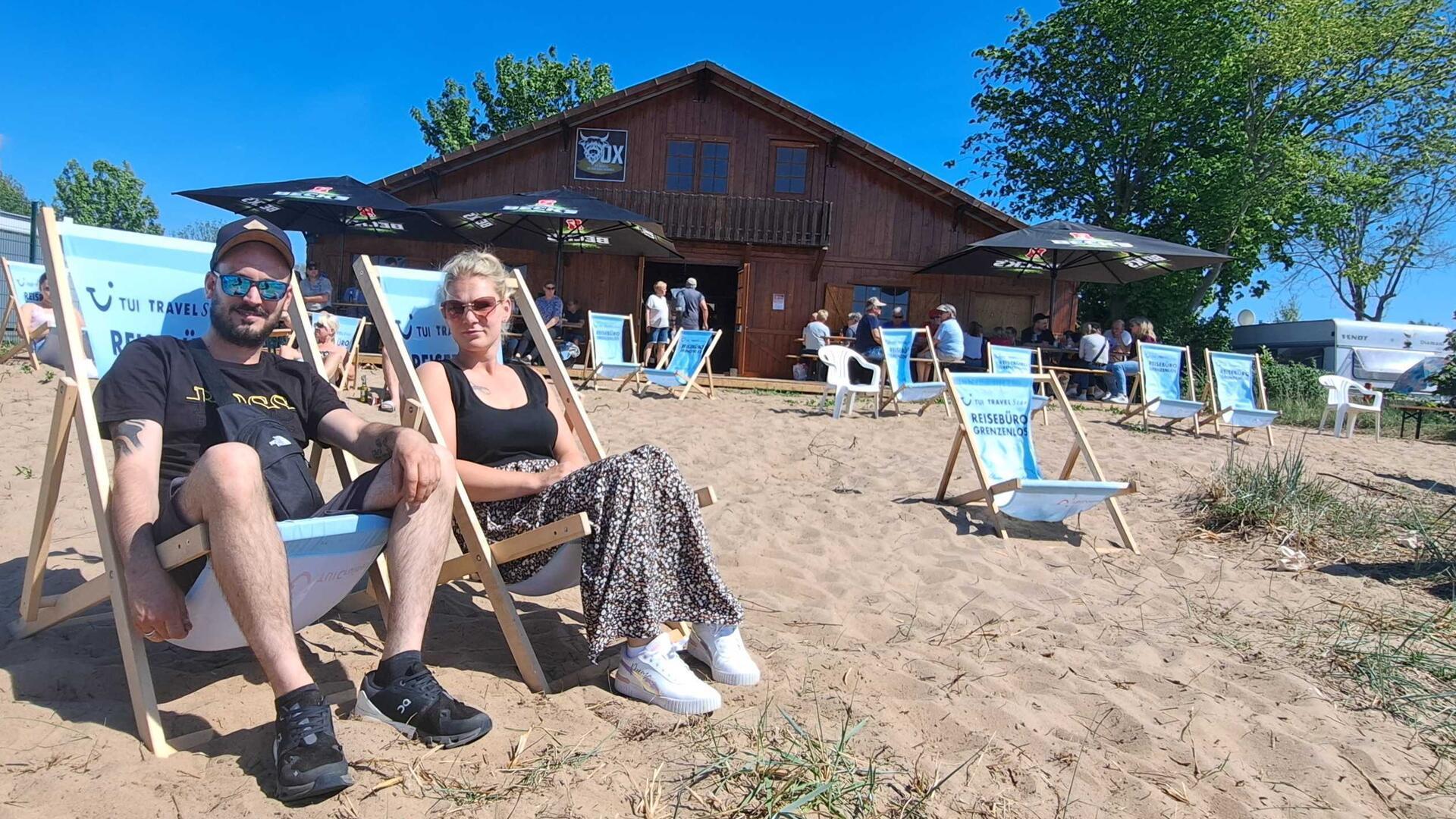 Chillen am Weserstrand: Jenny (30) und Patrick (34) sind mit dem Fahrrad aus Brake zur Eröffnung der neuen Strandhütte am Fähranleger in Sandstedt gekommen. „Wir wollten uns das neue Lokal anschauen. Es ist wirklich sehr schön direkt am Strand“, sagen sie. 