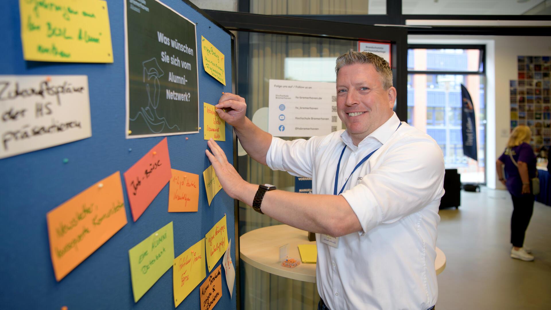 Christian Diestelkamp verewigt sich an der Pinwand beim Alumni-Treffen an der Hochschule Bremerhaven.